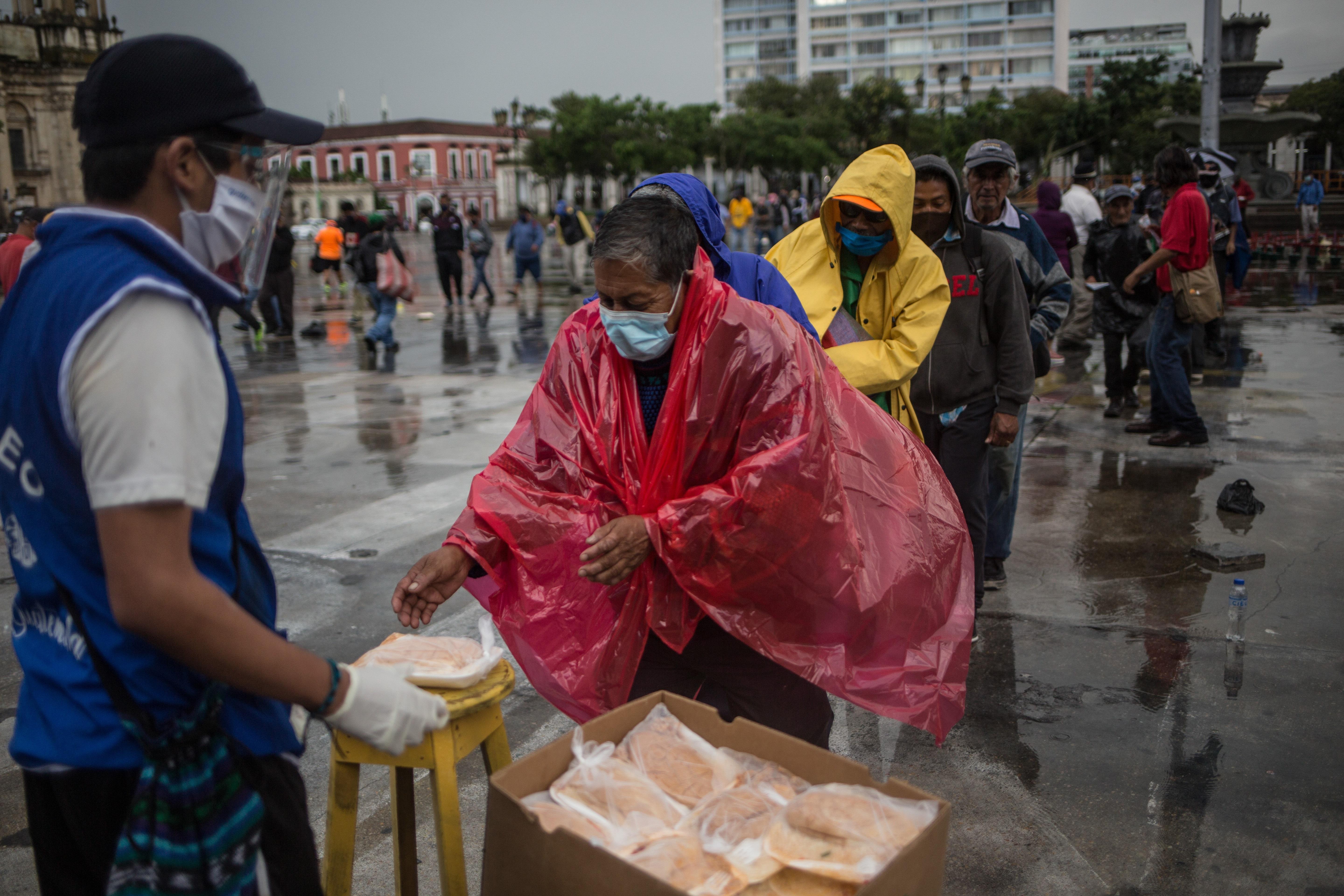 Un hombre recibe un almuerzo gratuito en la Plaza de la Constitución este 10 de septiembre por parte del proyecto La Olla Comunitaria, quienes han colaborado durante la crisis del coronavirus. Fotografía: Prensa Libre. 