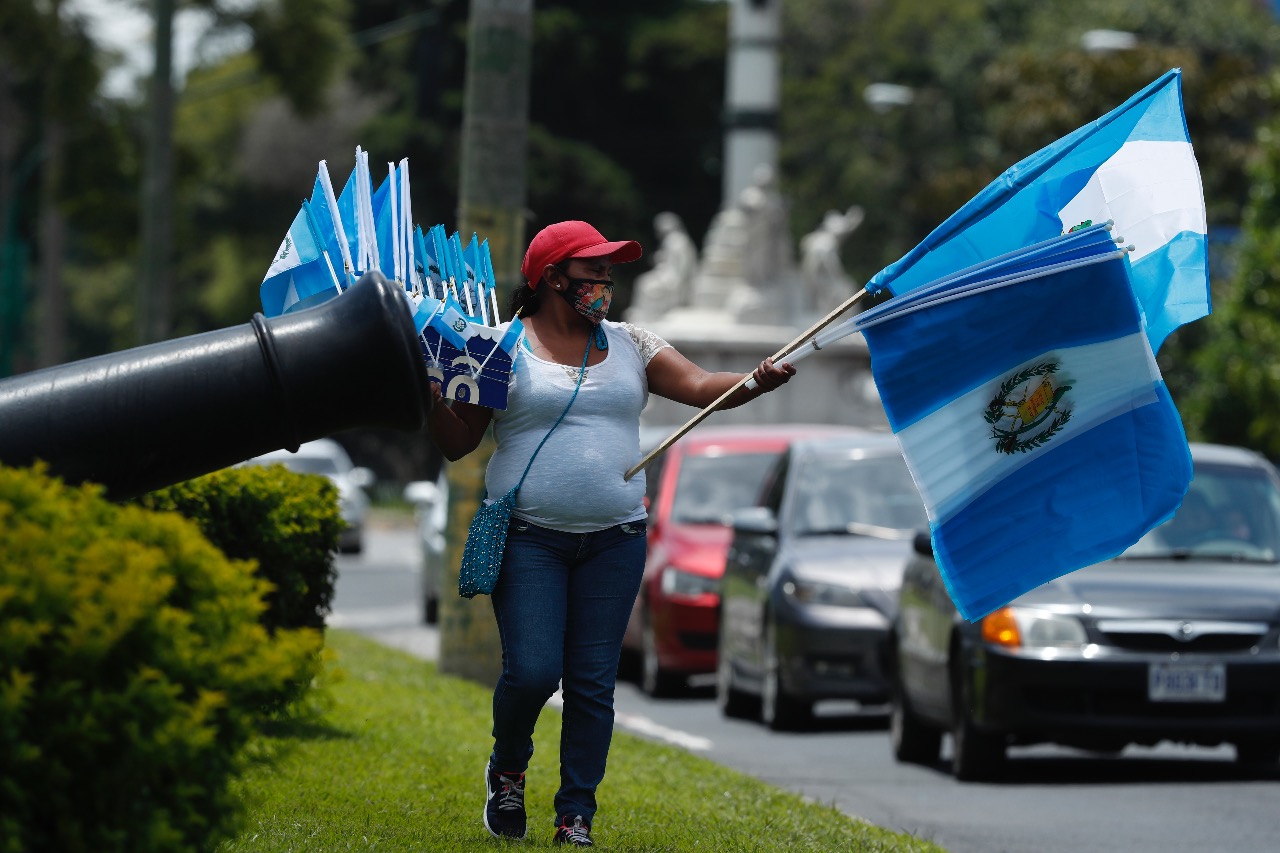 Lucía López camina en la avenida la Reforma, zona 10; vendiendo banderas durnate ocho horas al día. (Foto Prensa Libre: Esbin García)  