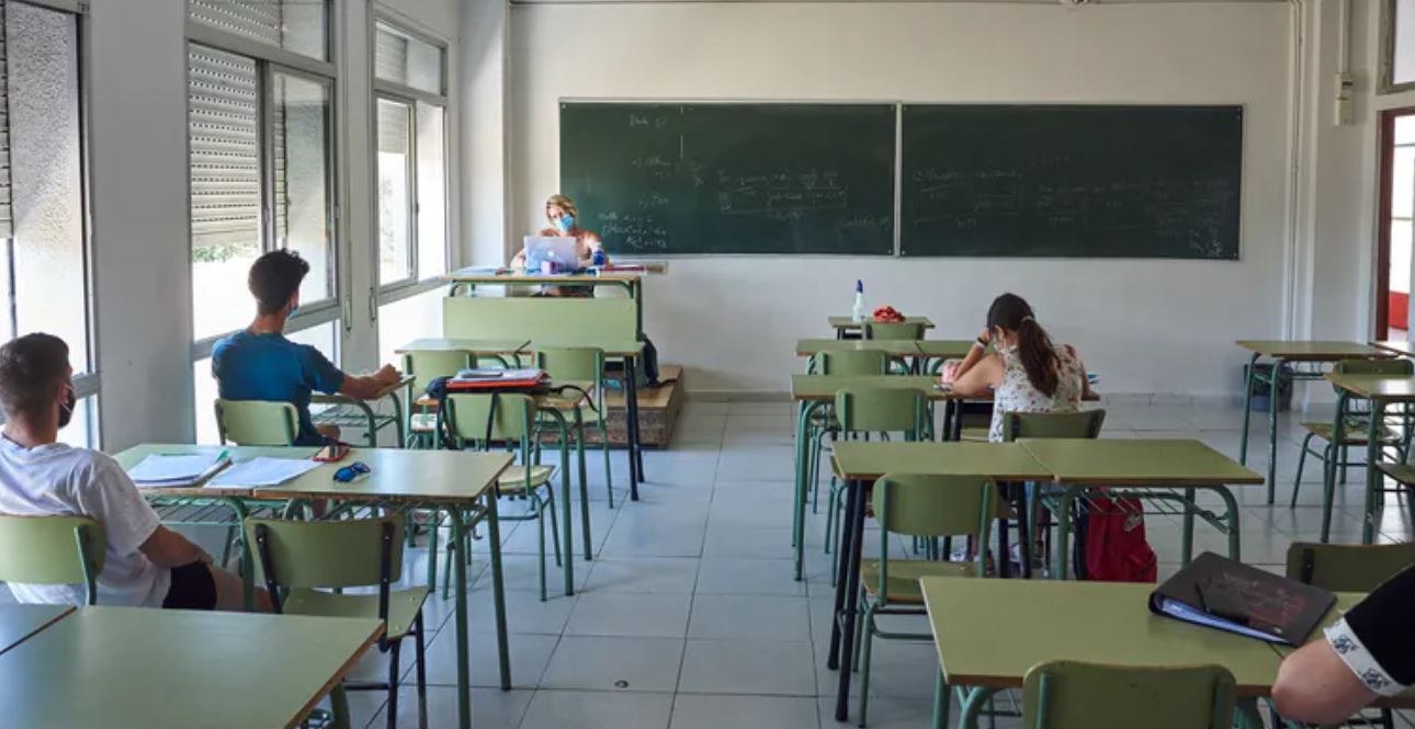 Aula con profesora y alumnos con mascarilla y una persona por cada par de pupitres.
Shutterstock / F. Altamirano