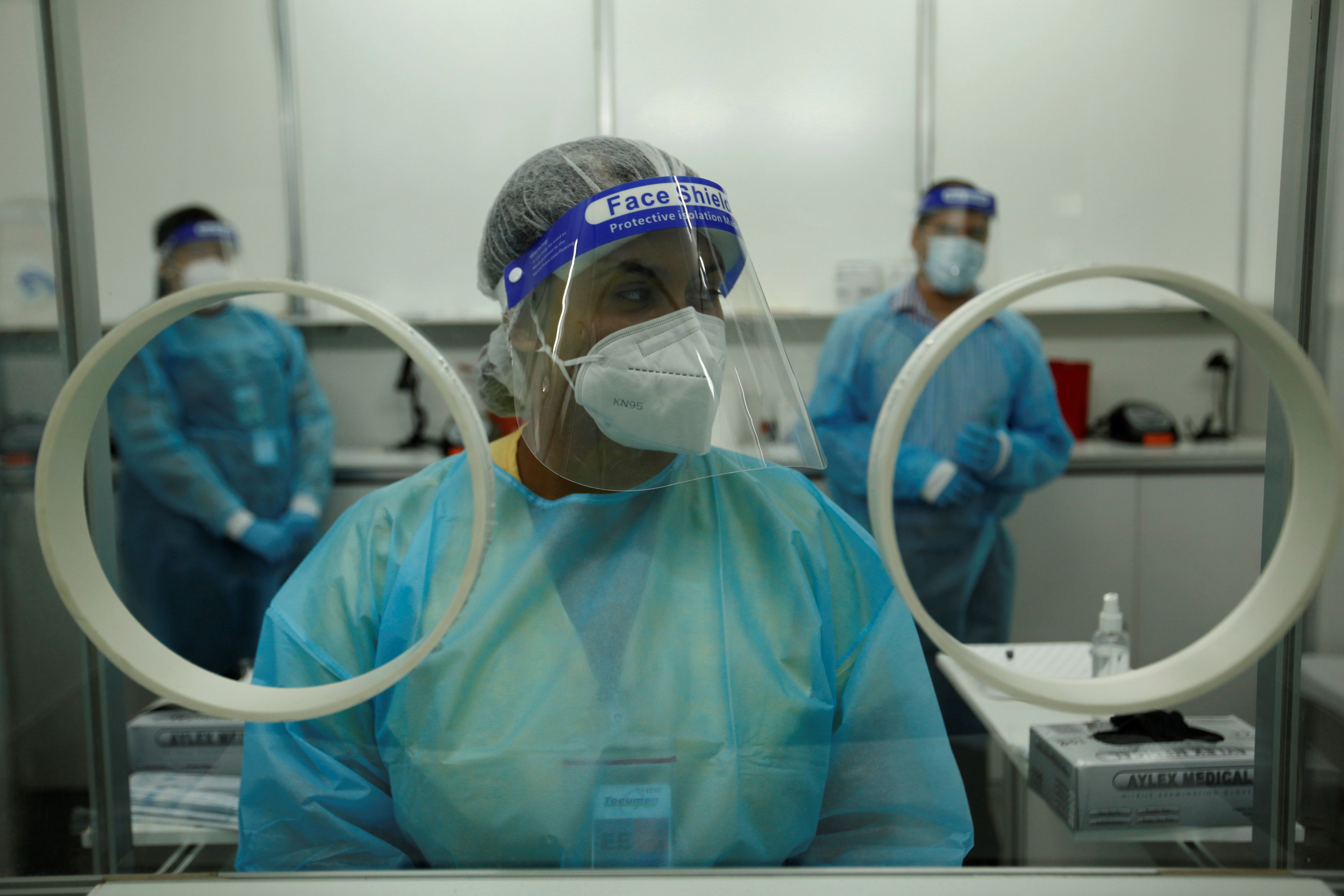 Personal médico privado realiza pruebas de hisopados para detectar covid-19. (Foto Prensa Libre: AFP)