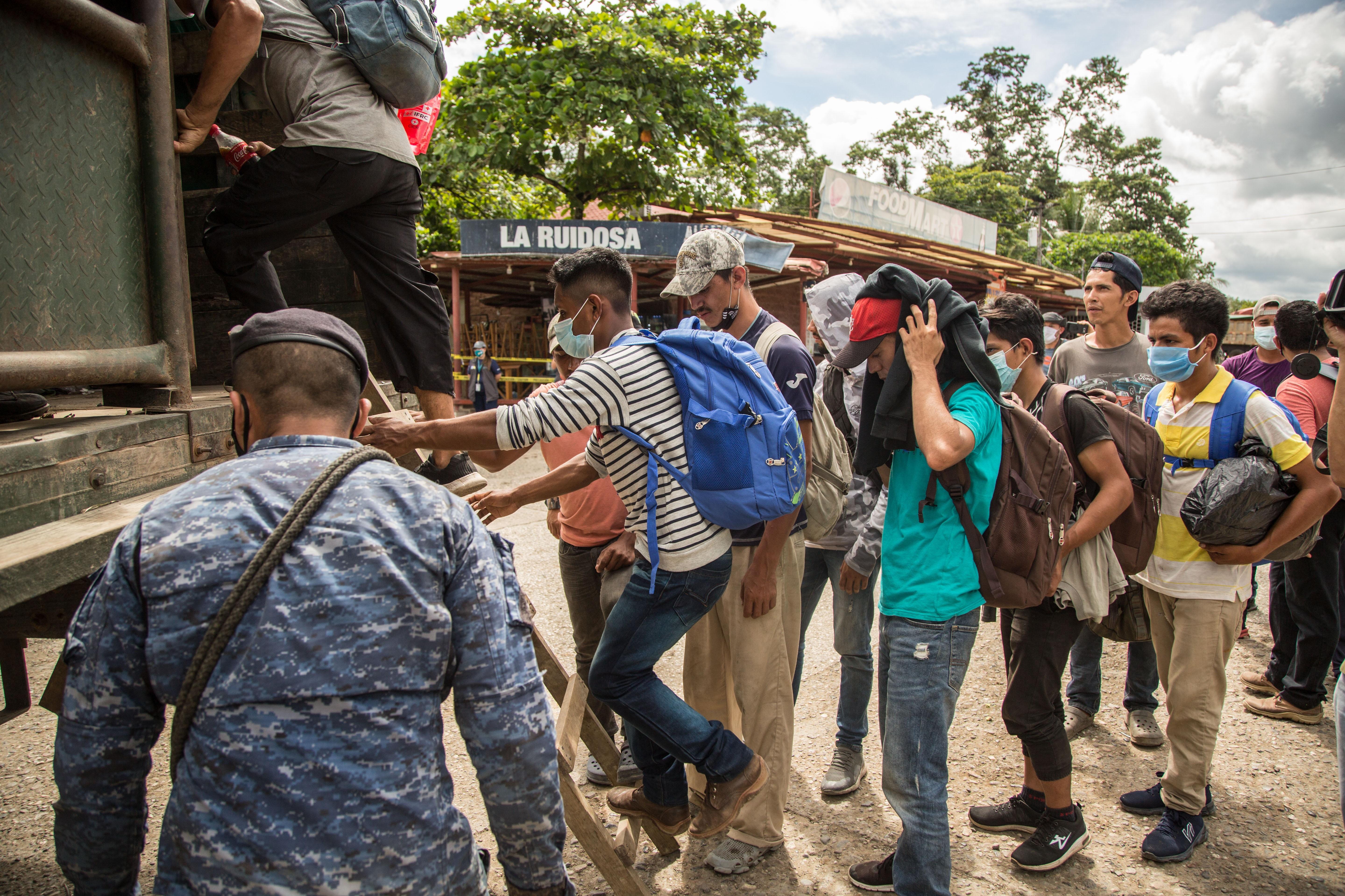 Un grupo de migrantes suben a un camión del ejército de Guatemala que los regresaría a la frontera entre Honduras y Guatemala el sábado, en Morales, Izabal. (Foto Prensa Libre: EFE)