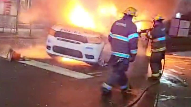 Bomberos trabajan en un vehículo policial en llamas durante las protestas después de la muerte de Walter Wallace Jr., un hombre negro que fue baleado por la policía en Filadelfia, Pensilvania, EE.UU., el 27 de octubre de 2020. (Foto Prensa Libre: Voa Noticias)