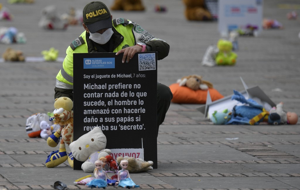 Un policía observa algunos de los peluches colocados como protesta en Colombia. (Foto: AFP) 