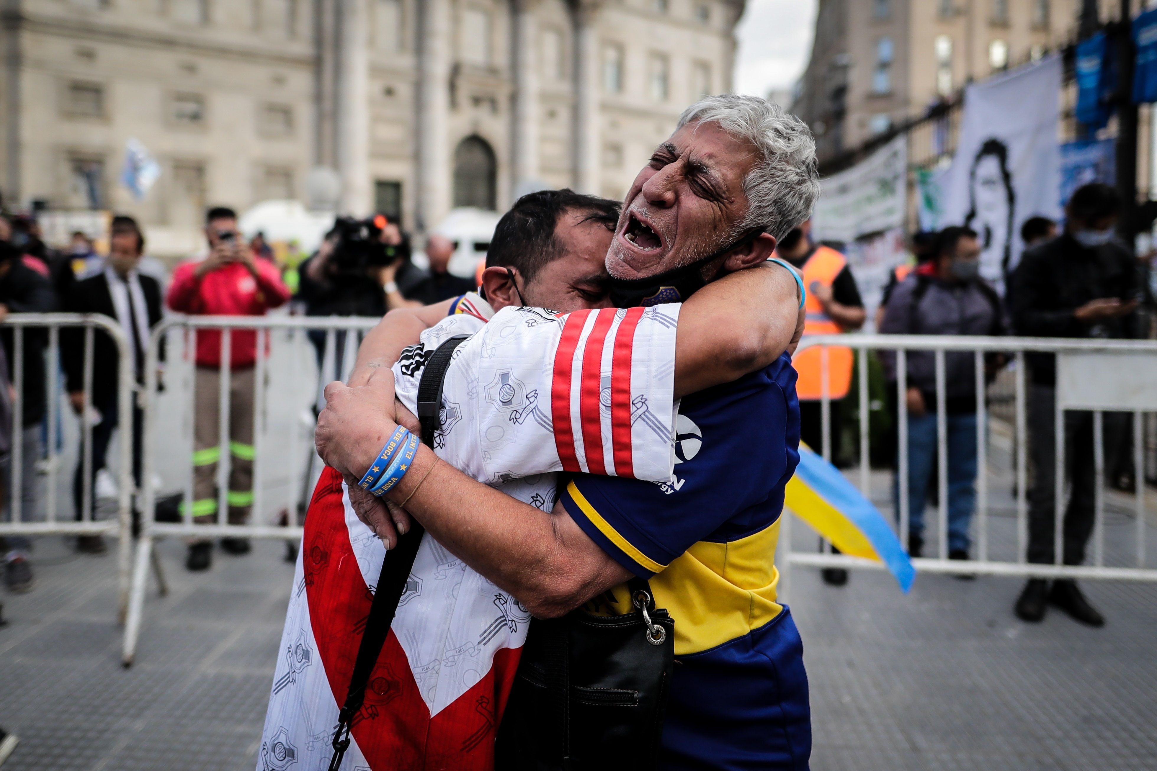 Dos seguidores de River Plate y Boca Juniors lloran por la partida de Diego Armando Maradona. (Foto Prensa Libre: EFE)