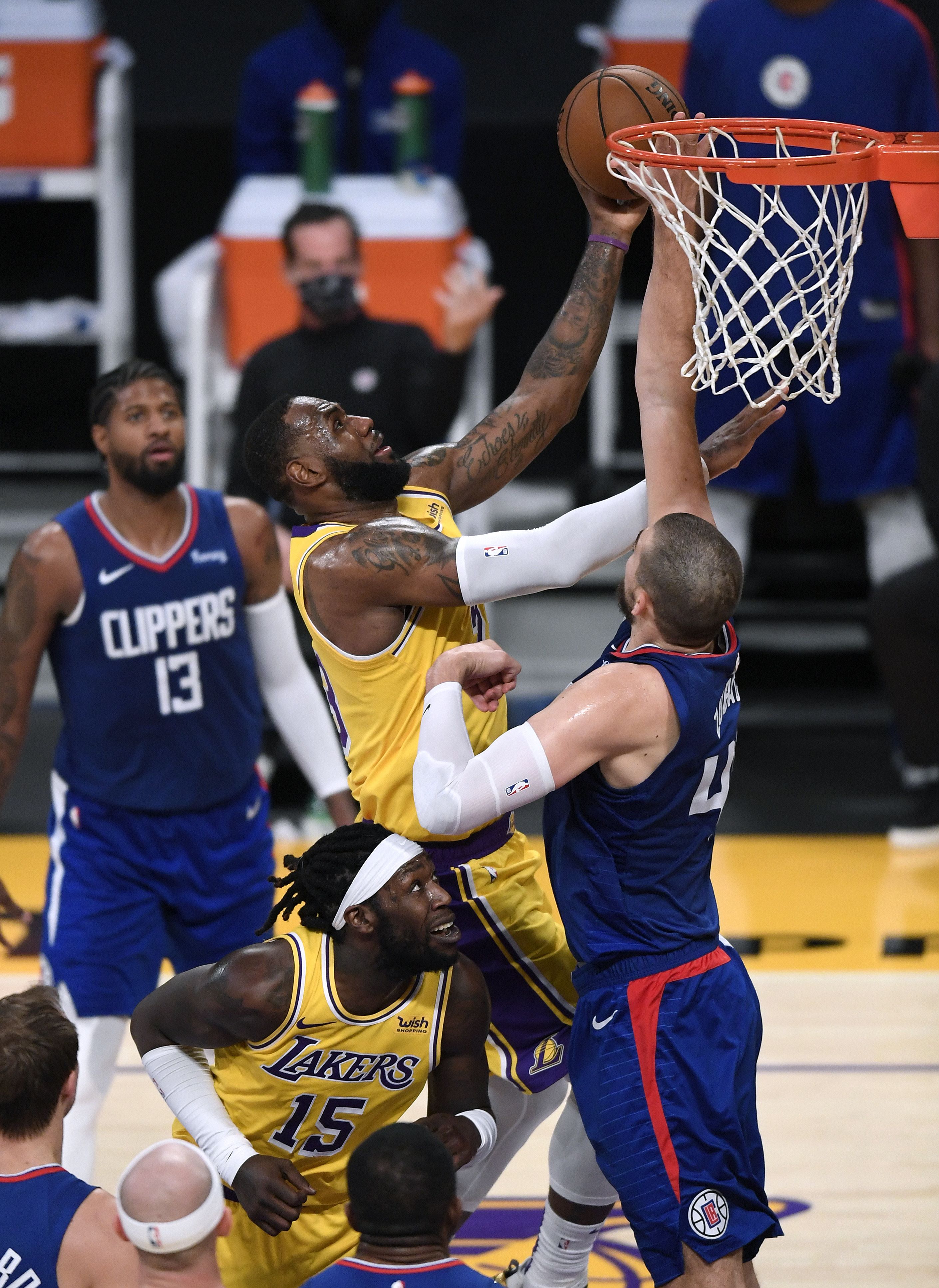 LeBron James de Los Angeles Lakers anota frente a Ivica Zubac y  Paul George de los Clippers. Foto Prensa Libre: AFP.