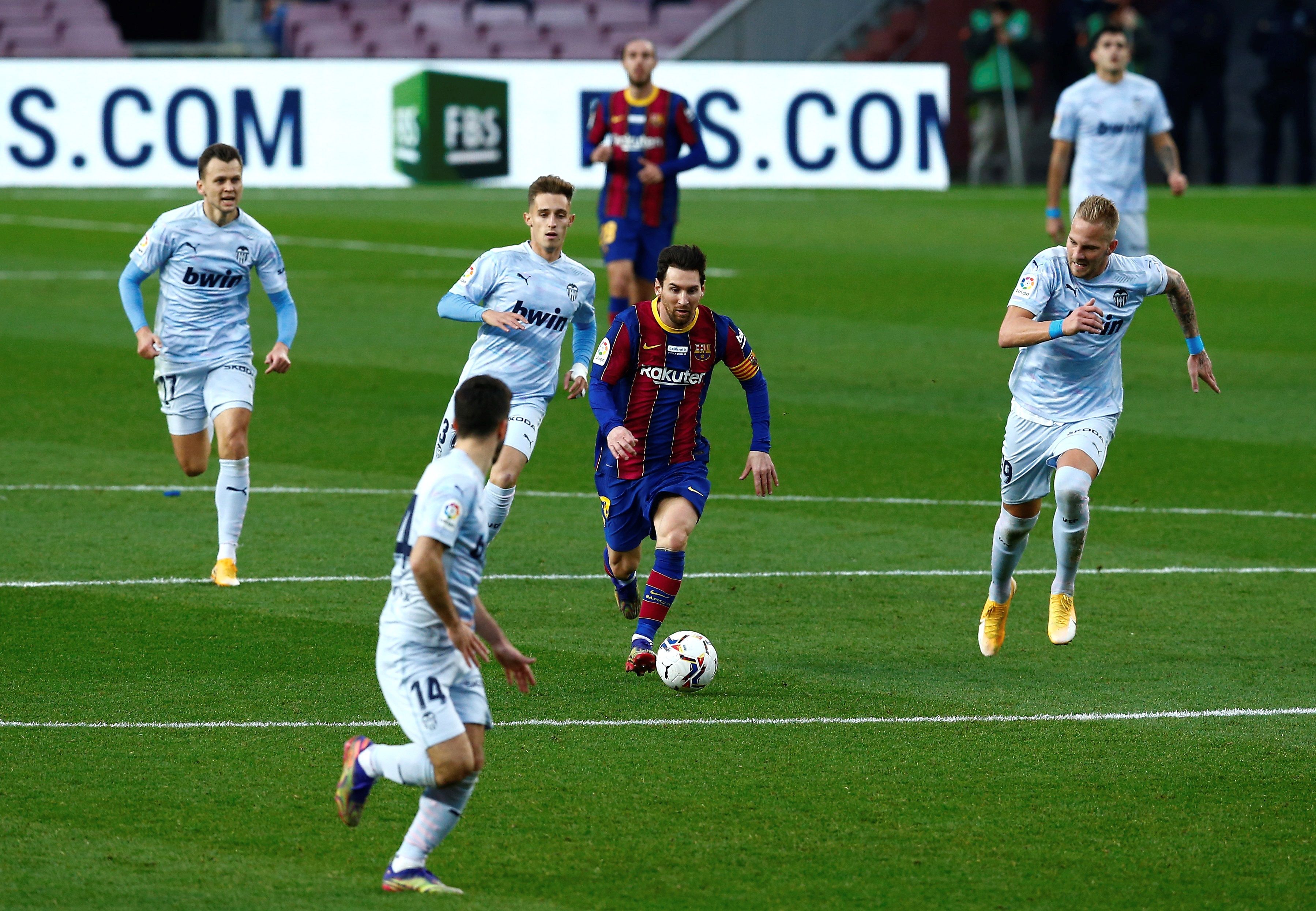 BARCELONA, 19/12/2020.- El jugador del FC Barcelona Lionel Messi (c), y el jugador del Valencia CF Uros Racic (d), durante el partido de la decimocuarta jornada de La Liga Santander de fútbol en el Camp Nou.- EFE/ Enric Fontcuberta.