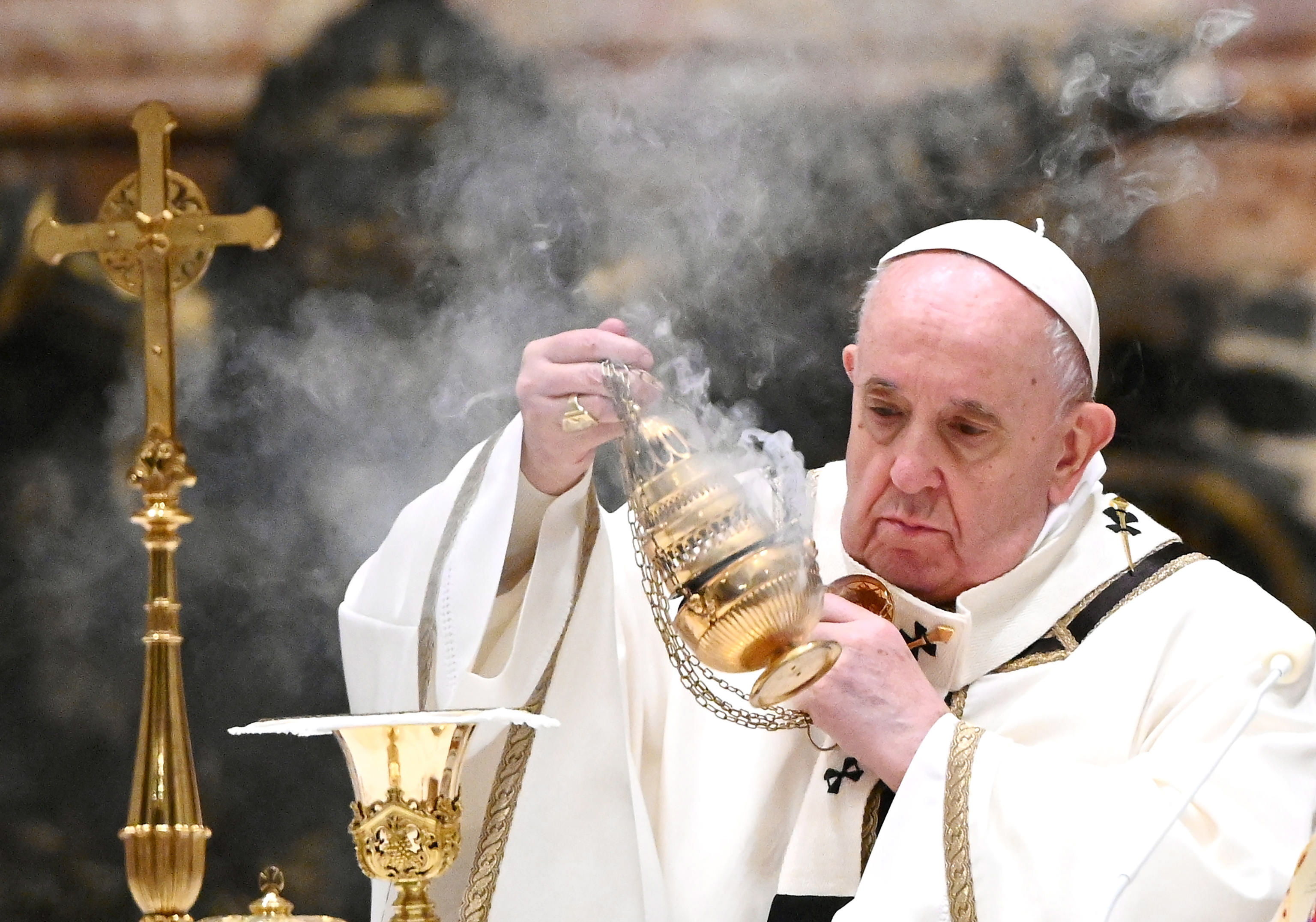 La misa comenzó con el anuncio del nacimiento con la lectura del antiguo texto de las "Kalendas" y luego Francisco descubrió una imagen del Niño Jesús ya situada a un lado del altar y le besó la rodilla. Fotografía: EFE. 