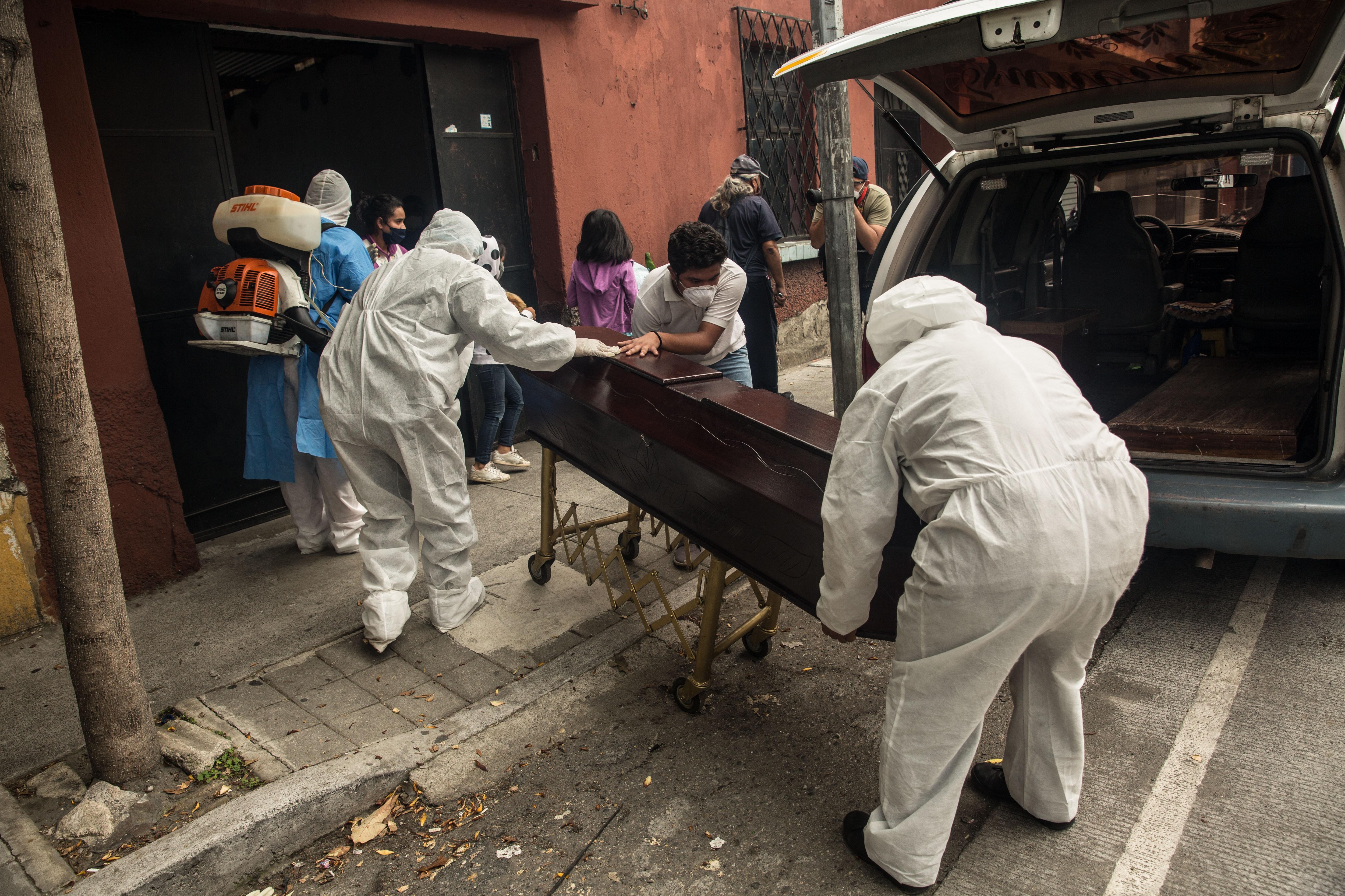 AME8839. CIUDAD DE GUATEMALA (GUATEMALA), 11/01/2021.- Fotografía de archivo fechada el 29 de junio de 2020, que muestra a paramédicos mientras retiran el cuerpo de un hombre fallecido por coronavirus, en Ciudad de Guatemala (Guatemala). Guatemala se convirtió este domingo en el primer país de Centroamérica en llegar a los 5.000 fallecidos por la covid-19, aunque según expertos la cifra es mucho mayor debido al subregistro de decesos. EFE/ Esteban Biba