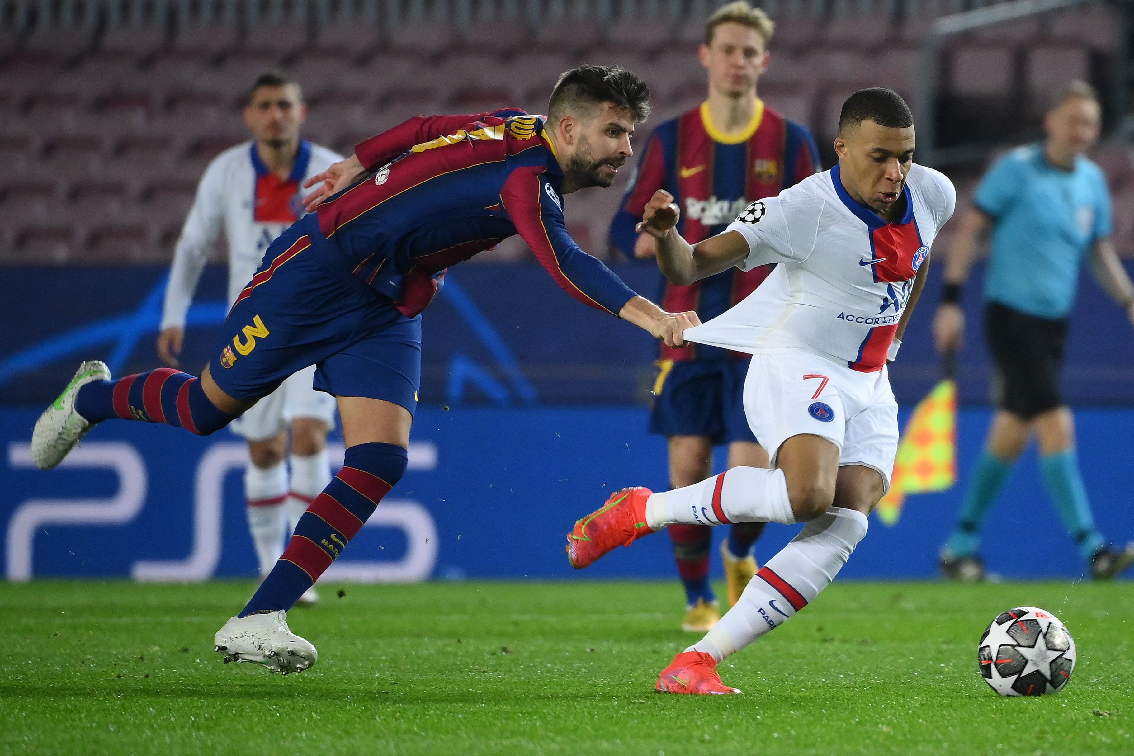 Barcelona's Spanish defender Gerard Pique (L) challenges Paris Saint-Germain's French forward Kylian Mbappe during the UEFA Champions League round of 16 first leg football match between FC Barcelona and Paris Saint-Germain FC at the Camp Nou stadium in Barcelona on February 16, 2021. (Photo by LLUIS GENE / AFP)