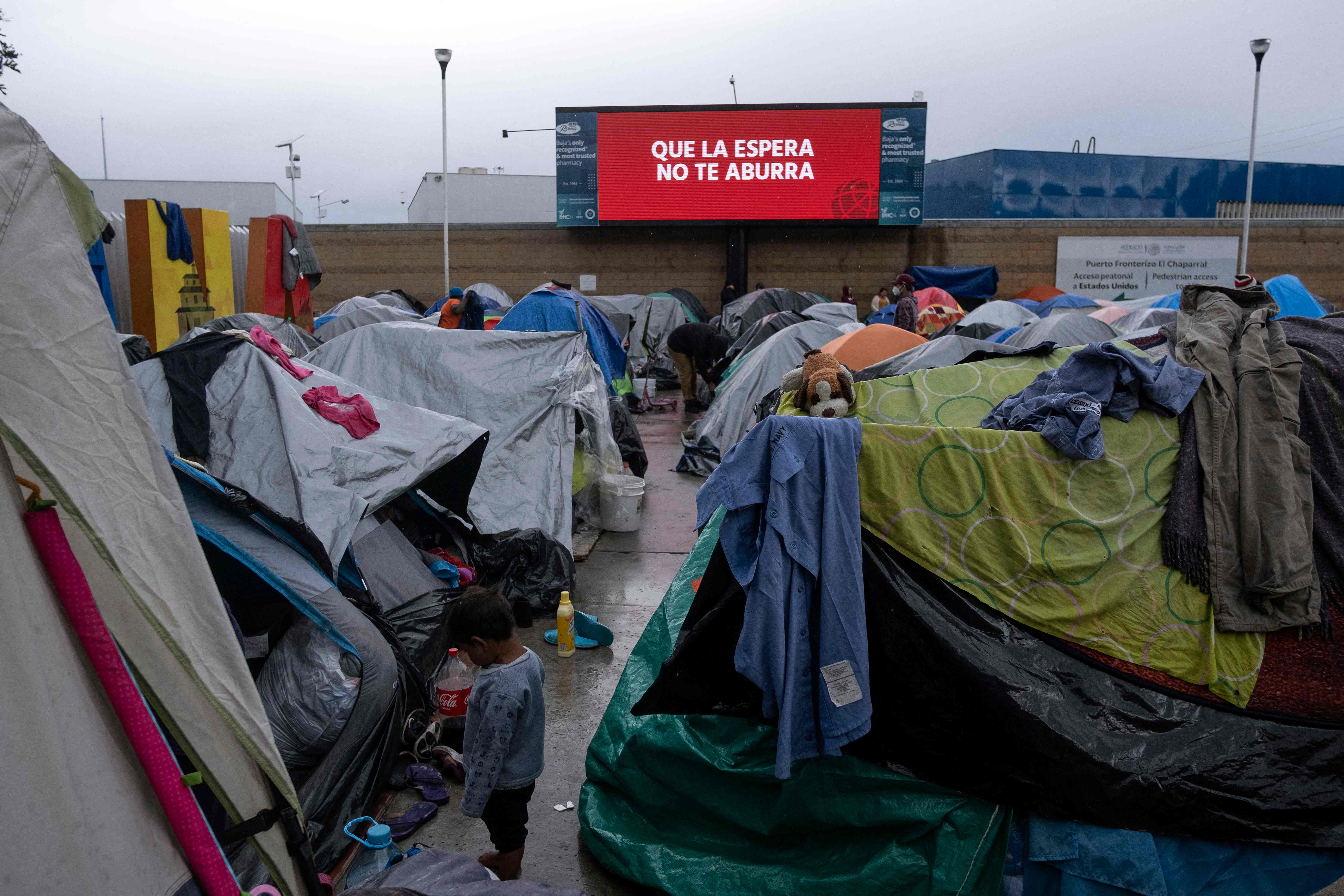 Un niño permanece fuera de unas carpas instaladas en Tijuana, frontera con EE. UU. donde los migrantes han empezado a acumularse debido a que intentan ingresar a EE. UU. (Foto Prensa Libre: AFP)