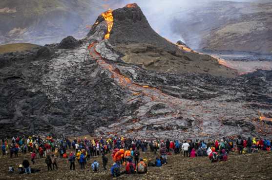 Los excursionistas observan la lava que fluye del volcán Fagradalsfjall en erupción a unos 40 km al oeste de la capital islandesa, Reykjavik. (Foto Prensa Libre: AFP)