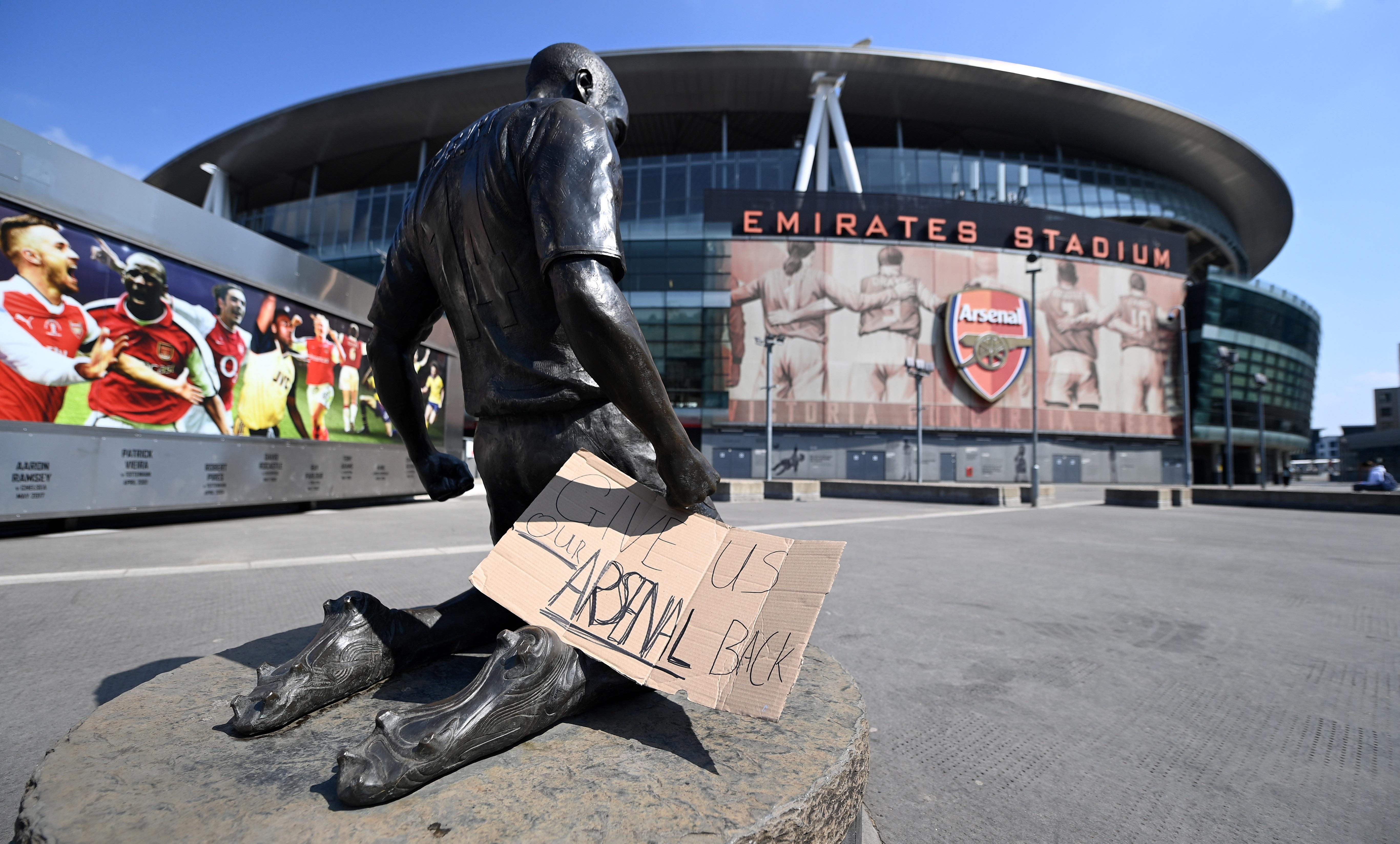 Un cartel con el mensaje "Devolvednos a nuestro Arsenal" colocado a las puertas del Emirates Stadium del club en Londres (REino Unido) este martes. La Autoridad británica de mercados y competencia (CMA, en inglés) "examinará cuidadosamente" si existen indicios de que el proyecto de Superliga europea de fútbol viola las leyes de competencia en el Reino Unido, indicó este martes un portavoz. Foto Prensa Libre: EFE.