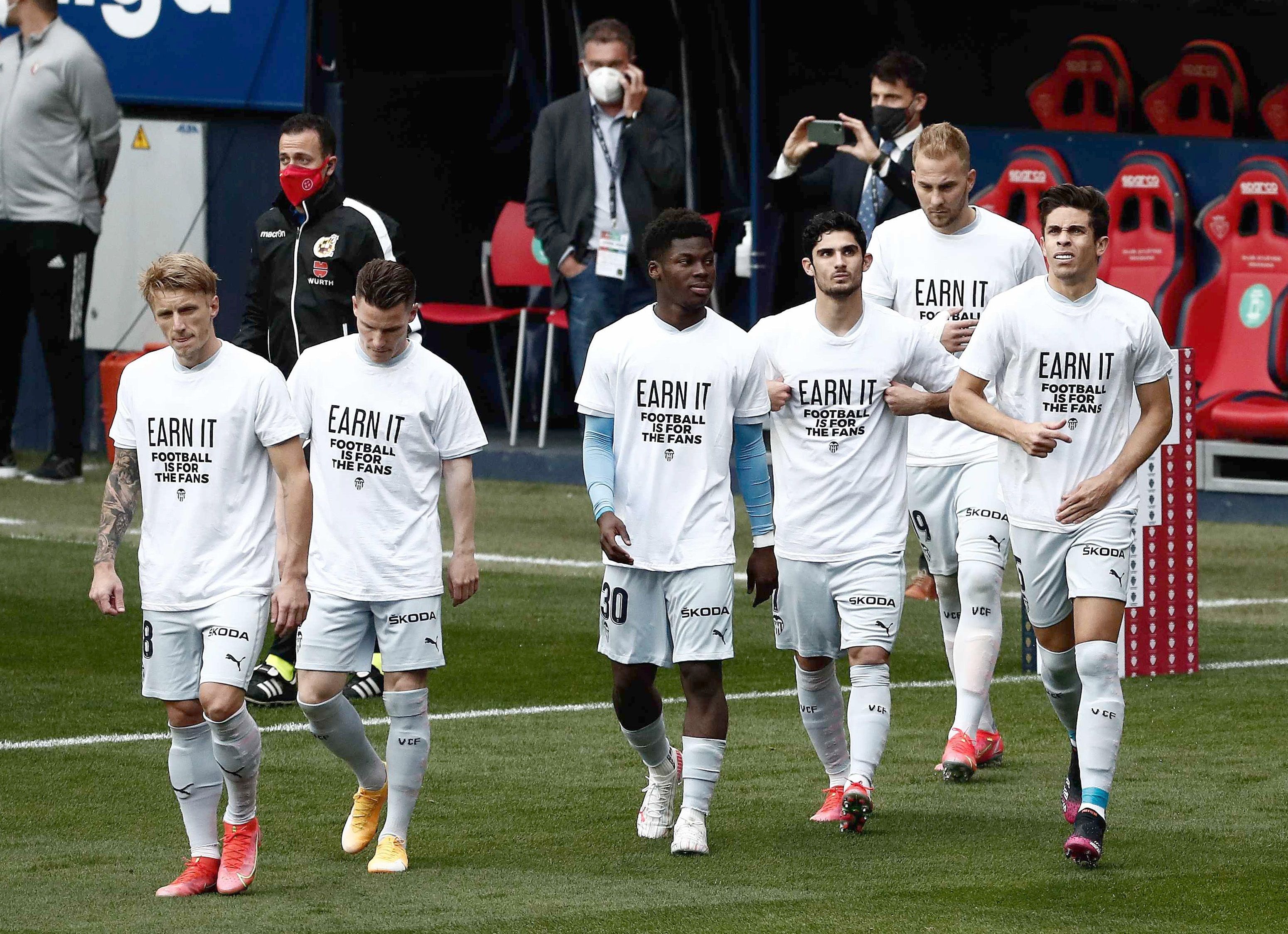 Los jugadores del Club Atlético Osasuna y del Valencia C. F. lucen unas camisetas con el lema 'Earn it. Football is for the fans' (Gánatelo. El fútbol es de los aficionados), para mostrar su rechazo al proyecto de Superliga. Foto Prensa Libre: EFE