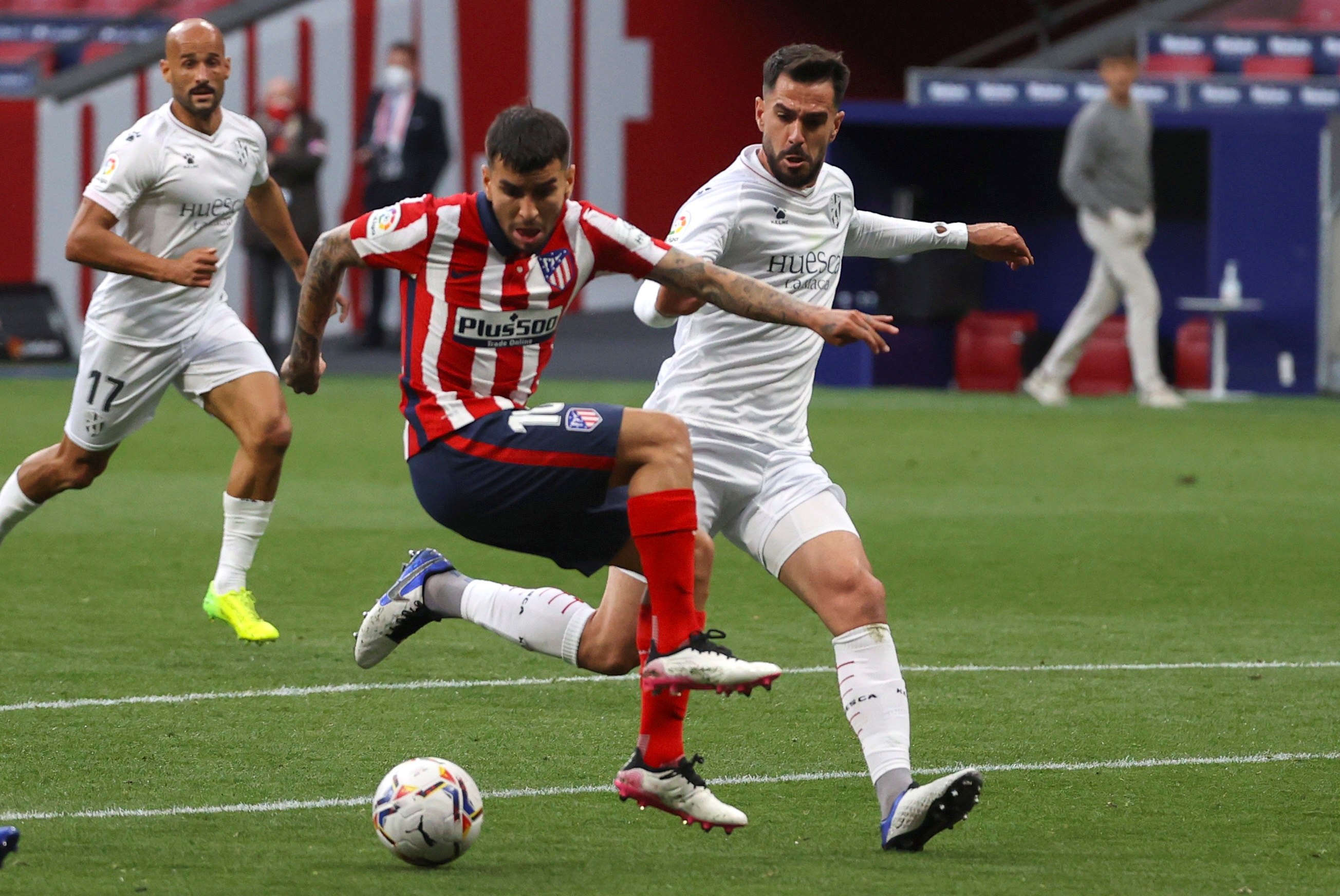 El delantero argentino del Atlético de Madrid, Ángel Correa pelea un balón con el centrocampista de la SD Huesca Pablo Insua en el encuentro de La Liga  de la jornada 31 disputado en el estadio Wanda Metropolitano en Madrid. Foto Prensa Libre: EFE.