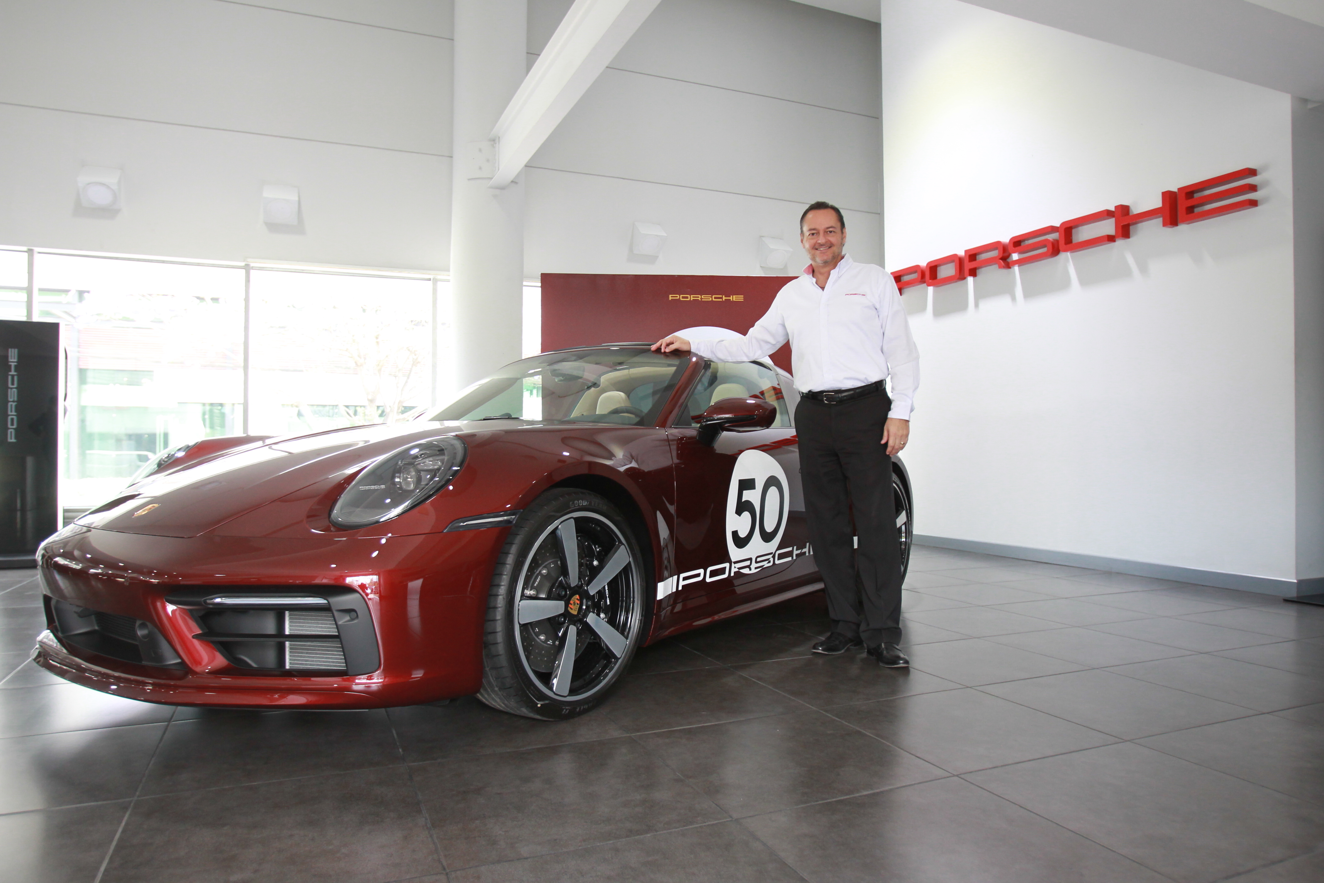 Miguel Castañeda gerente de marca Porsche en Grupo Los Tres, junto al 911 Targa 4S Heritage Design. Foto Prensa Libre: Norvin Mendoza