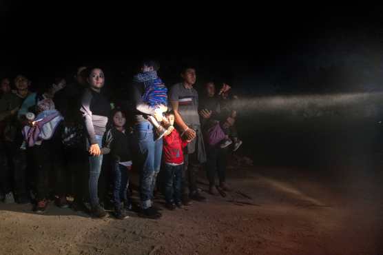 Migrantes junto a un vehículo de la Patrulla Fronteriza de EE. UU. Después de cruzar la frontera entre EE. UU. Y México en Roma, Texas. (Foto Prensa Libre: AFP)