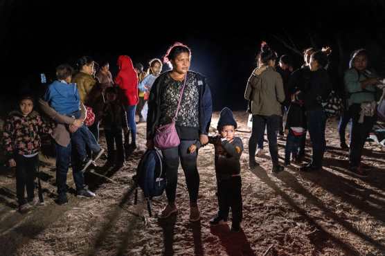 Una madre y un hijo hondureños, de 3 años, se paran en la orilla del Río Grande después de cruzar la frontera con México en Roma, Texas. (Foto Prensa Libre: AFP)