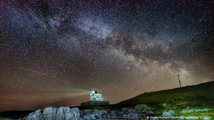  El núcleo de la Vía Láctea se hace visible en las primeras horas de la mañana del martes mientras se desplaza sobre el faro de Bamburgh, en Stag Rock, en Northumberland, Reino Unido.