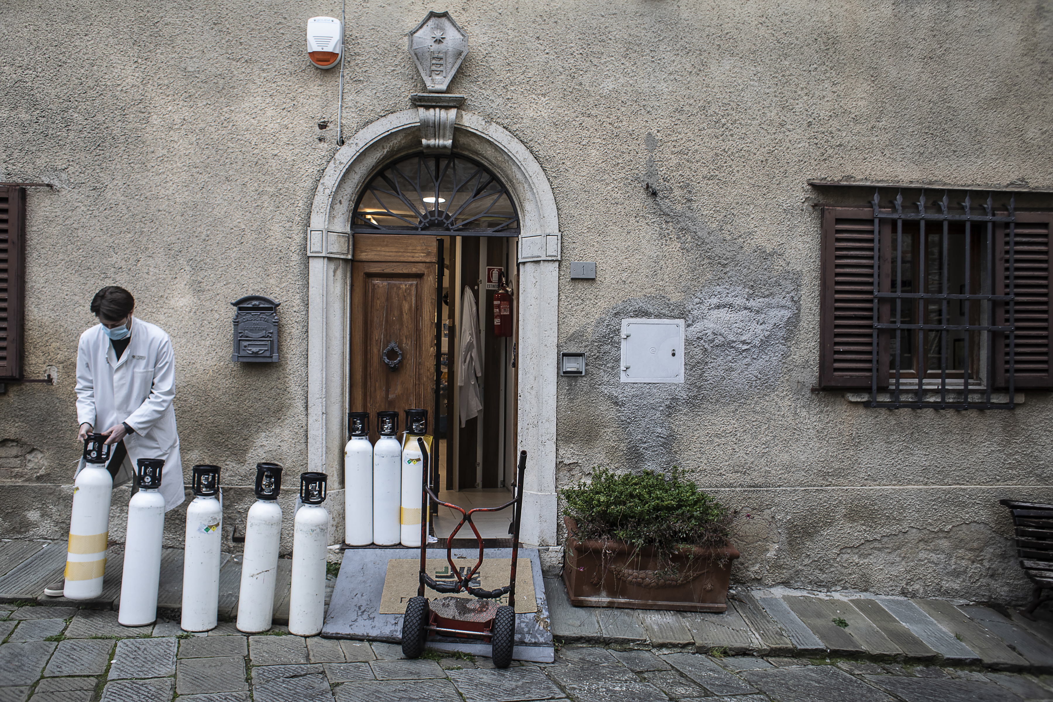 Lorenzo Berti, un farmaceuta local, alinea tanques de oxígeno vacíos en la parte trasera de una farmacia para ser remplazados con los llenos, en la población de Castellina in Chianti, ubicada en la región de la Toscana, en Italia, el 17 de diciembre de 2020. (Foto Prensa Libre: Nadia Shira Cohen/The New York Times)