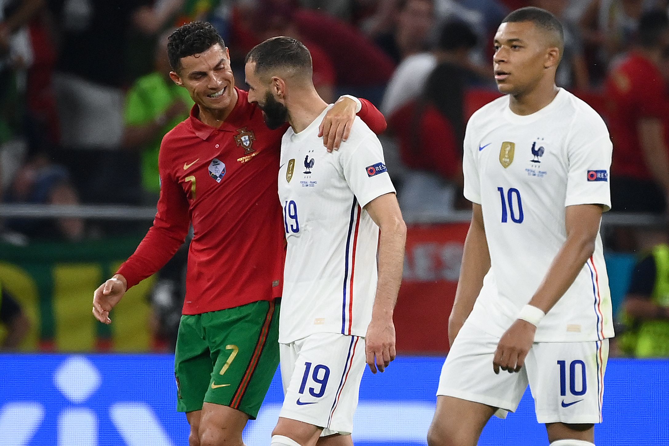 El delantero portugués, Cristiano Ronaldo, y el francés Karim Benzema caminan abrazados al terminar el primero tiempo del partido que empataron 2-2 este miércoles 23 de junio. Foto Prensa Libre: AFP.