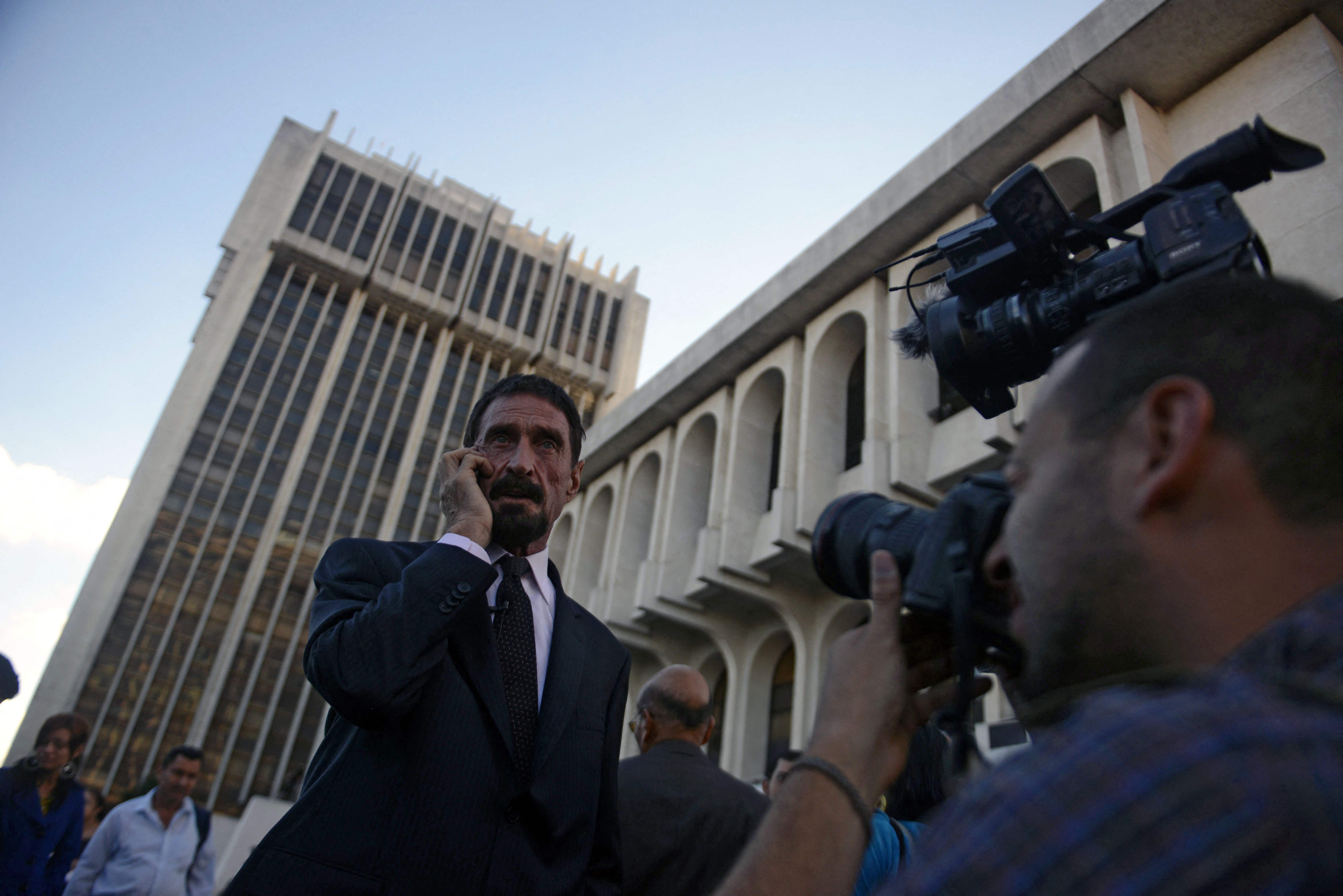 En esta foto de archivo tomada el 4 de diciembre de 2012, el pionero del software antivirus estadounidense John McAfee habla en su teléfono celular frente a la Corte Suprema en la Ciudad de Guatemala. (Foto: AFP)