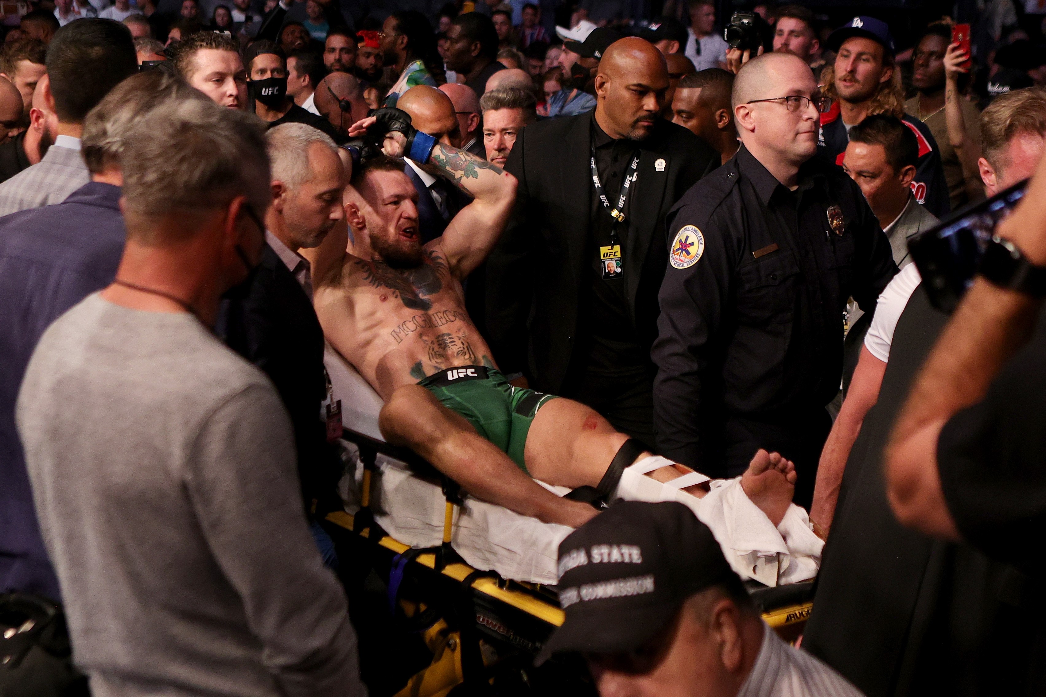 El irlandés Conor McGregor sale en una camilla después de haber peleado ante Dustin Poirier en el T-Mobile Arena. El luchador sufrió una fractura de tibia y peroné. Foto Prensa Libre: AFP. 