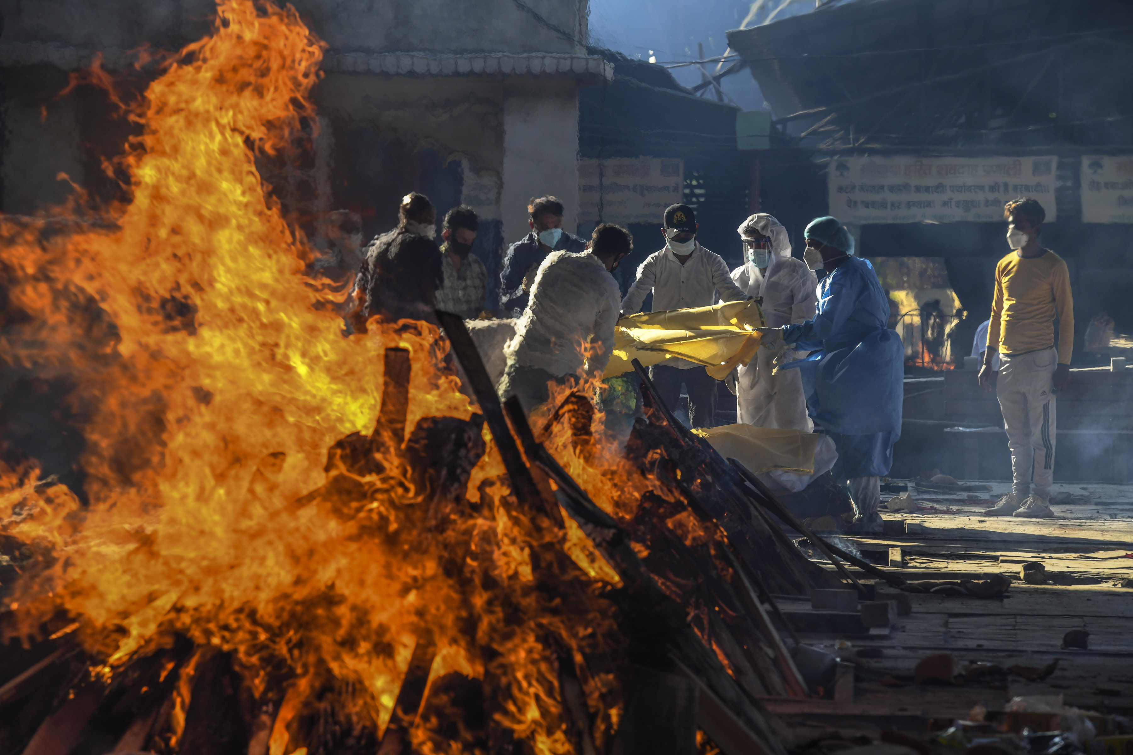 Familiares realizan los ritos funerarios de una víctima de COVID-19 en un crematorio de Nueva Delhi, el 24 de abril de 2021. (Atul Loke/The New York Times)