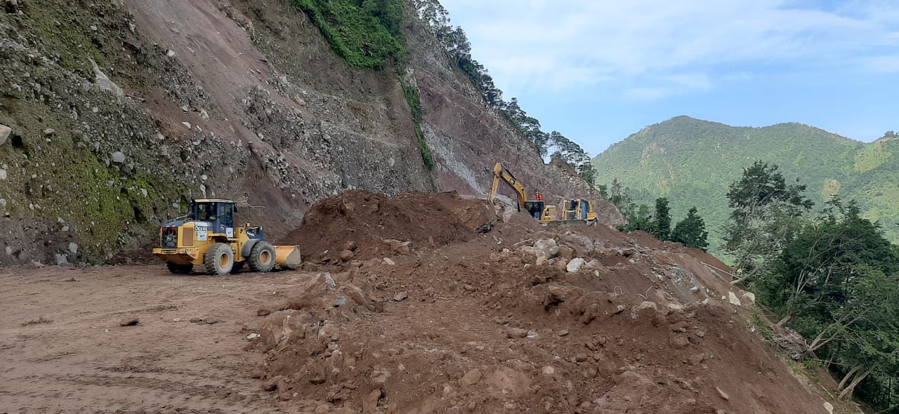 Socorristas utilizan maquinaria para retirar rocas y tierra que dejaron sepultados varios vehículos en Tajumulco, San Marcos. (Foto Prensa Libre: Conred)