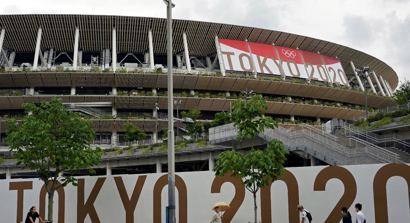 Transeúntes pasan por el Estadio Nacional, el estadio principal de los Juegos Olímpicos de Tokio 2020, en Tokio, Japón. (Foto Prensa Libre: EFE) 