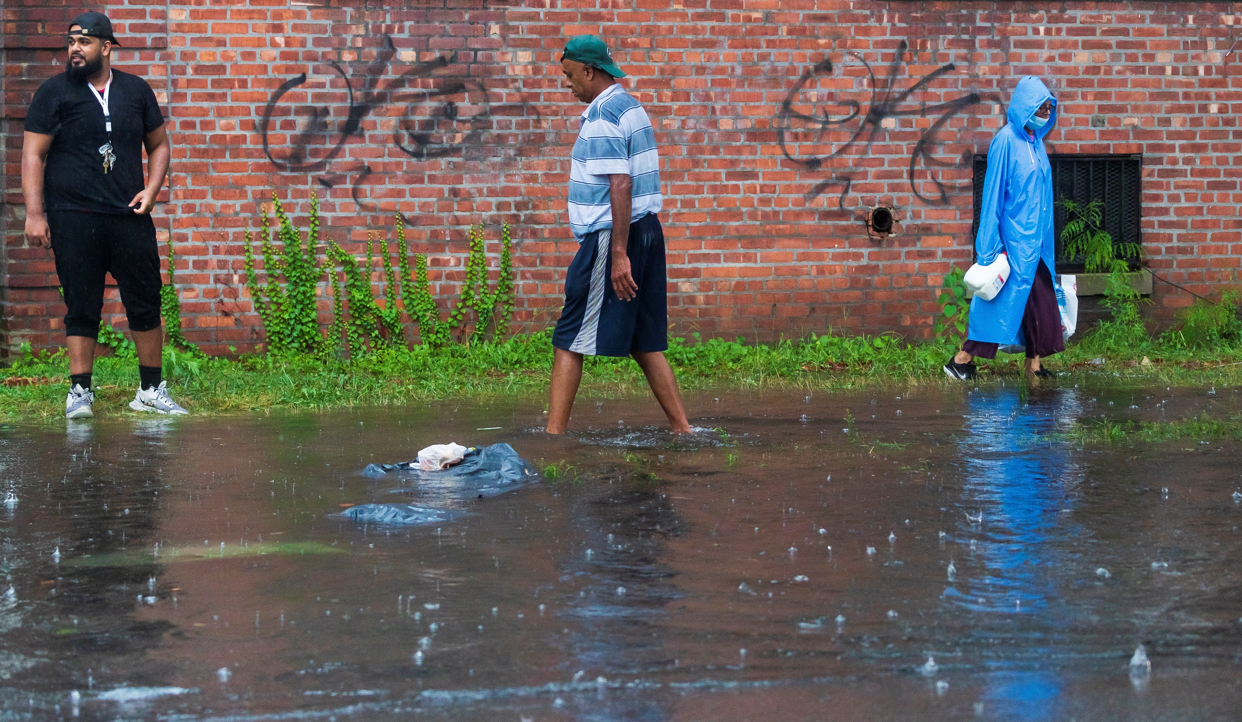 Personas navegan por una acera inundada mientras la lluvia de la tormenta tropical Henri cae en el distrito de Queens de Nueva York, Nueva York, EE. UU., el 22 de agosto de 2021. (Foto:  Prensa Libre: EFE) 