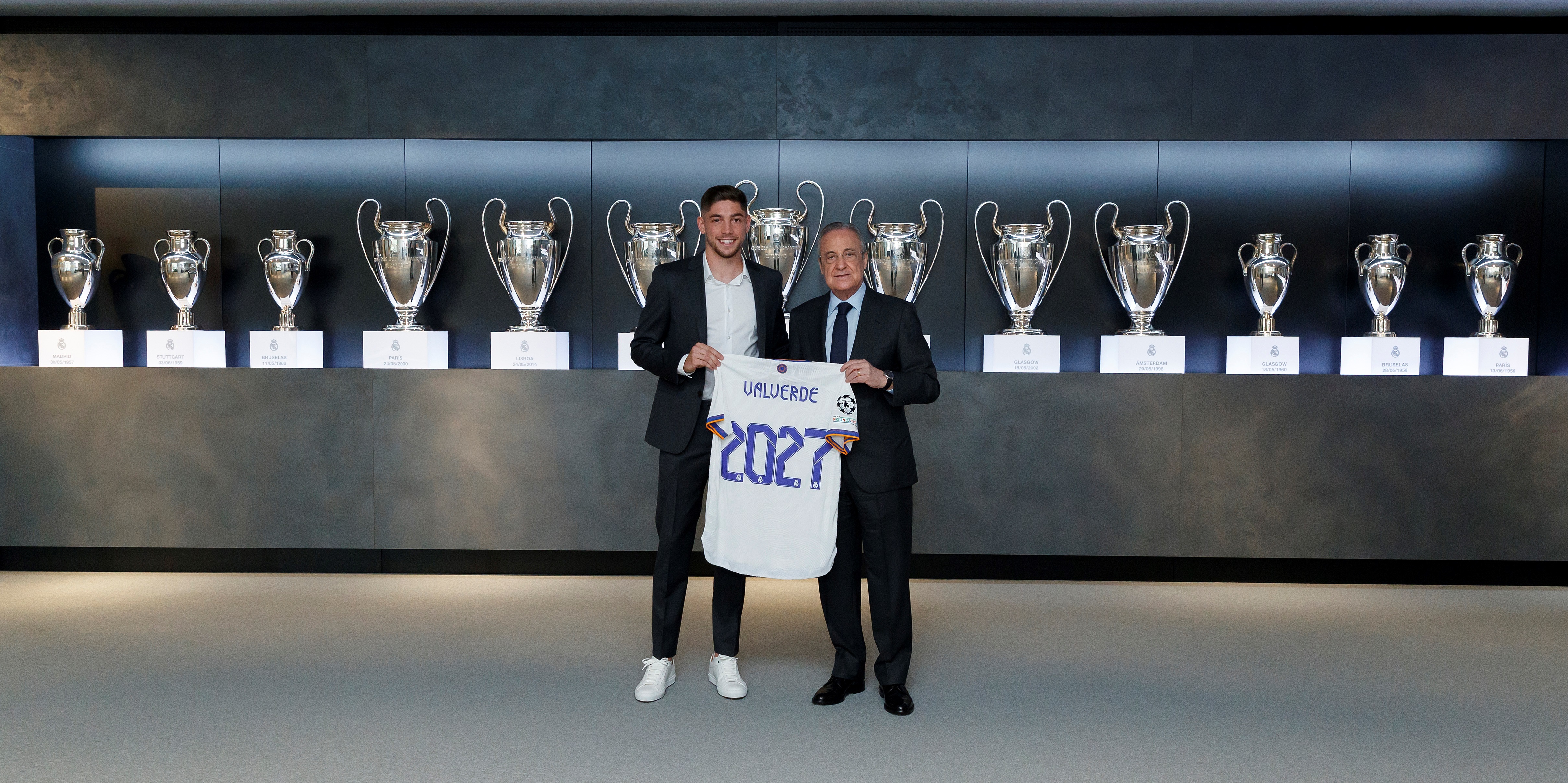 El presidente del Real Madrid, Florentino Pérez (d), posa junto con el centrocampista uruguayo Fede Valverde (i), que este martes 24 de agosto firmó su renovación con el club blanco hasta el 30 de junio de 2027. Con esta ya son tres las renovaciones que se han dado en el equipo de Carlo Ancelotti en las últimas semanas tras la del delantero francés Karim Benzema, el portero belga Thibaut Courtois y el defensor español Dani Carvajal. Foto Real Madrid.