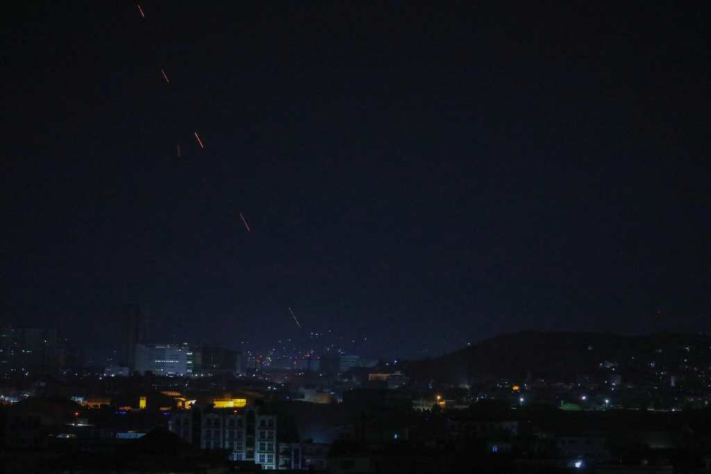 Periodistas captan el momento en que en Kabul hacen varios disparos para celebrar la retirada de los tropas estadounidenses. (Foto Prensa Libre: AFP)