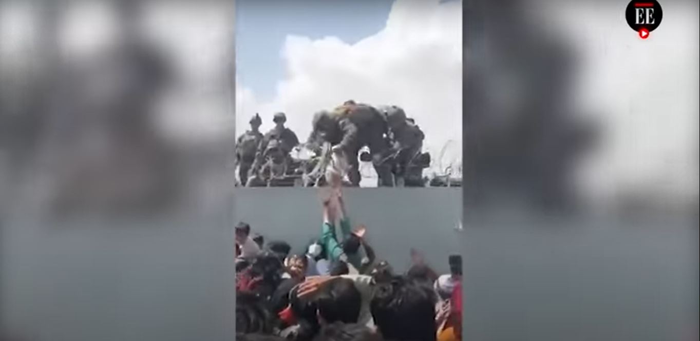 Momento en el que el bebé es entregado por encima del muro. (Foto Prensa Libre: Captura de pantalla)