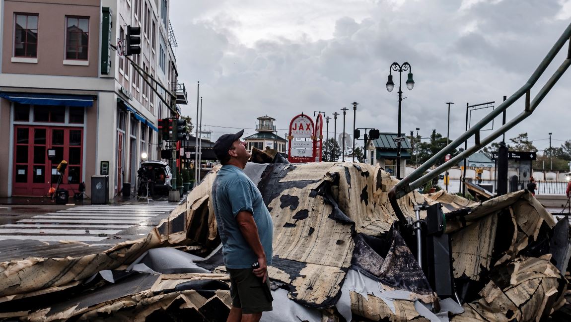 Un hombre mira hacia arriba junto a un trozo de techo que arrancó un edificio debido al huracán Ida en Nueva Orleans. (Foto Prensa Libre: EFE) 