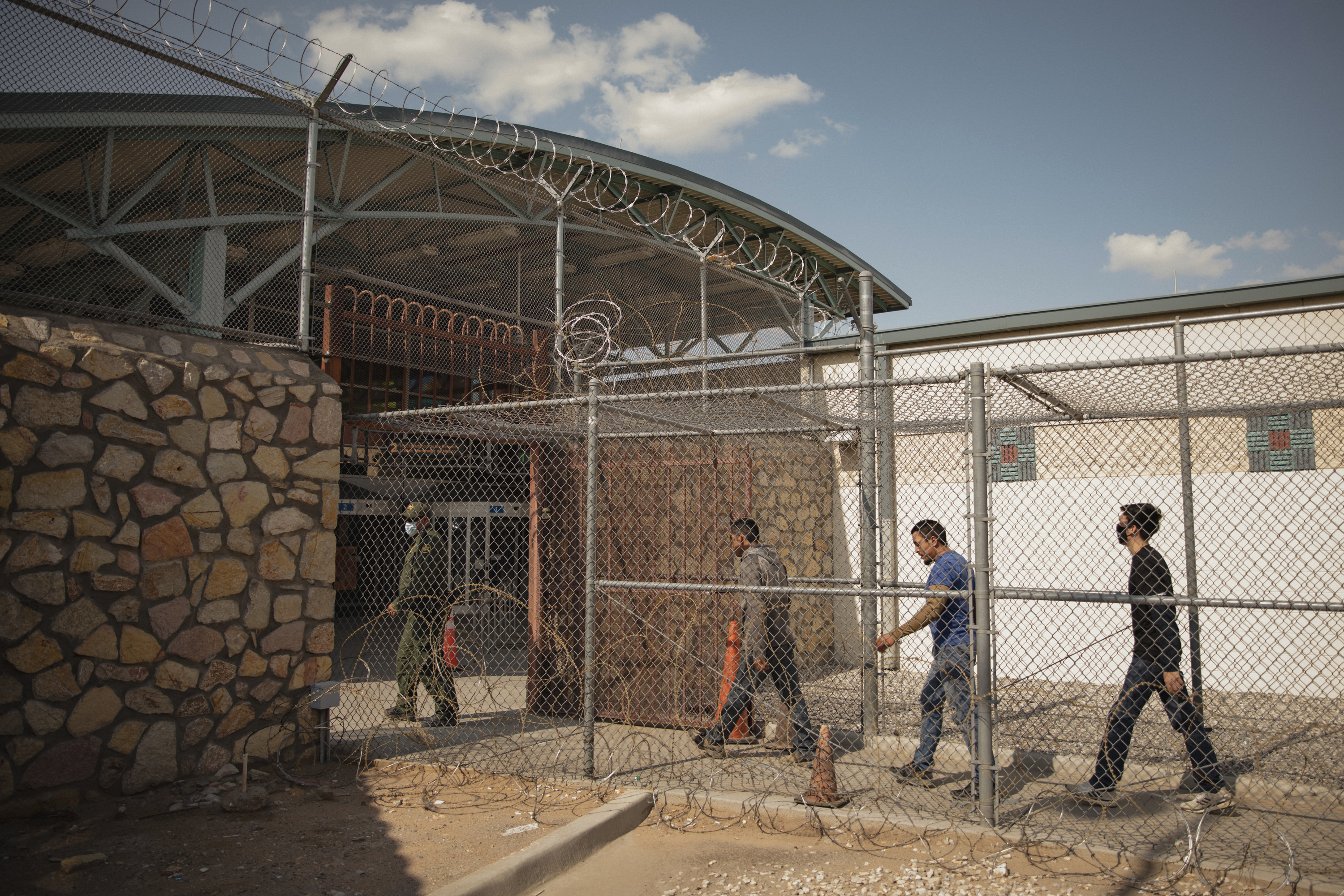 Los migrantes son escoltados a un puente fronterizo para ser deportados de regreso a México, en El Paso, Texas, el 21 de julio de 2021. En los días caninos del verano, cuando los cruces de migrantes en la frontera mexicana generalmente disminuyen, la afluencia este año ha sido implacable. (Foto Prensa Libre: Adria Malcolm / The New York Times)