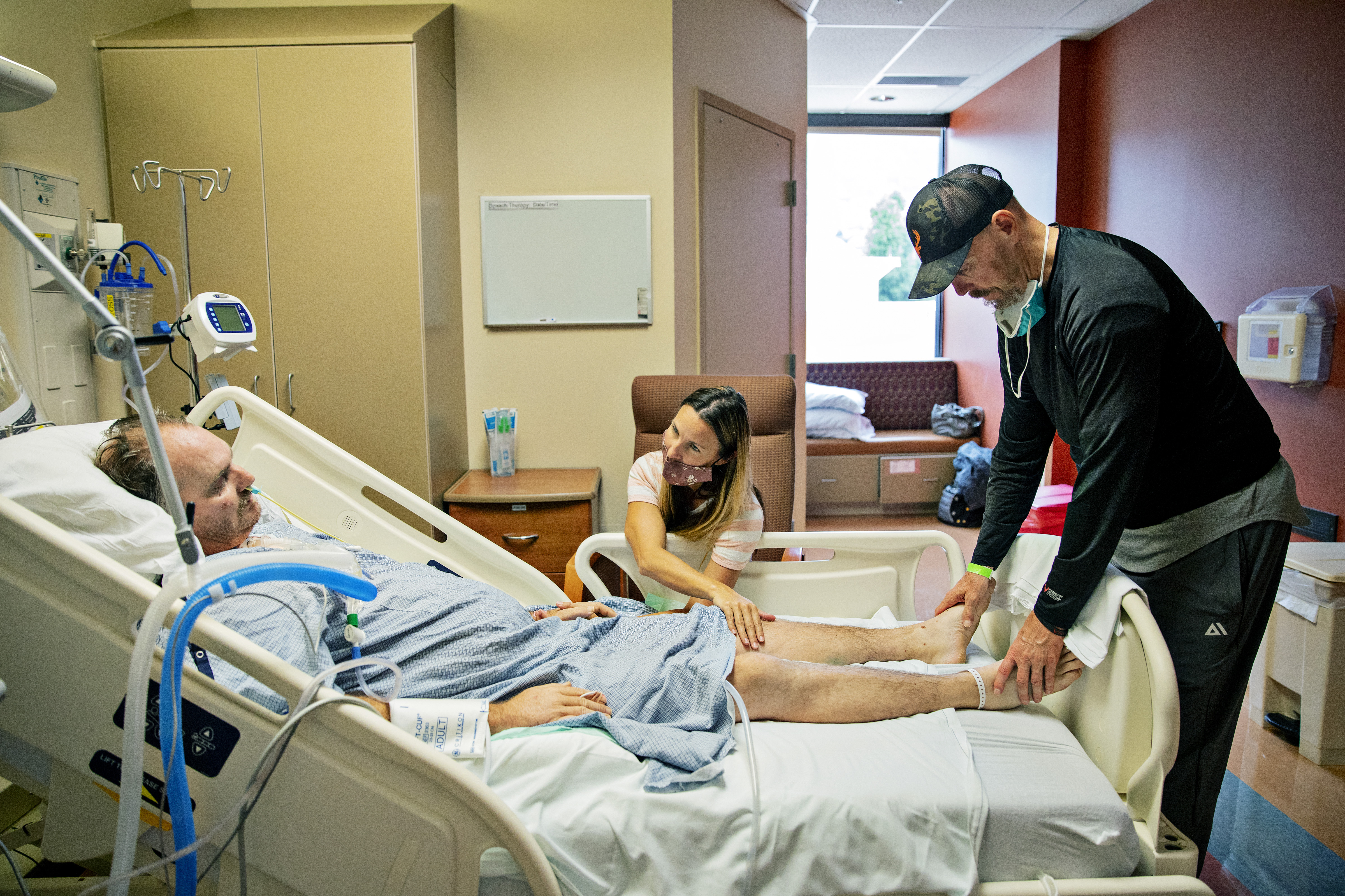 Glen Arnell, a la derecha, y Mindy Greene visitan a su esposo, Russ Greene, en el Hospital de Especialidades de Utah Valley, en Provo, Utah, el 23 de julio de 2021. (Foto Prensa Libre: Kim Raff/The New York Times)