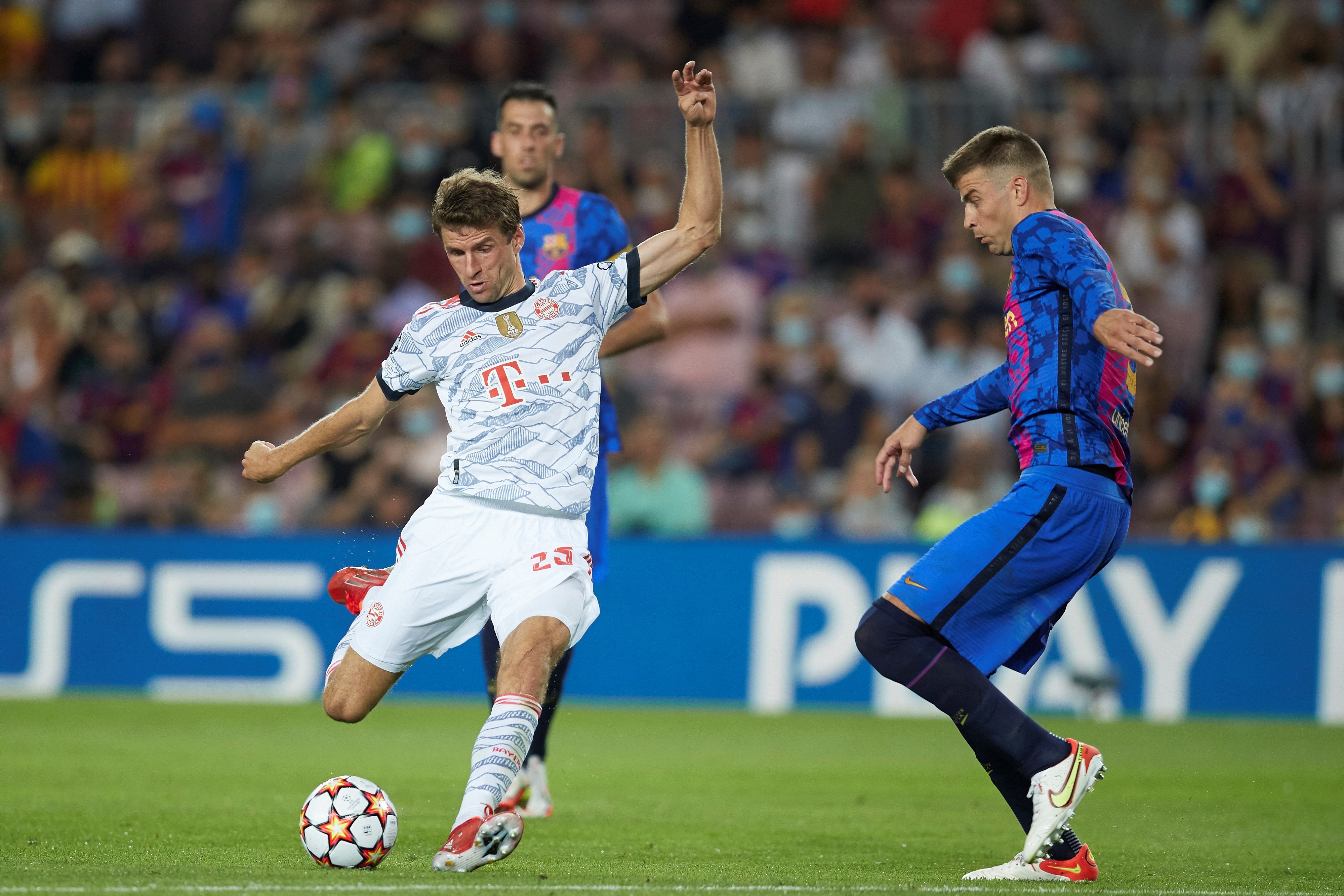 El centrocampista del Bayern Múnich Thomas Müller (i) dispara ante el defensa del FC Barcelona Gerard Piqué, durante el partido de la fase de grupos de la Liga de Campeones que jugaron en el Camp Nou el 15 de septiembre de 2021. Aquella vez ganaron los alemanes 0-3. Foto Prensa Libre: EFE.