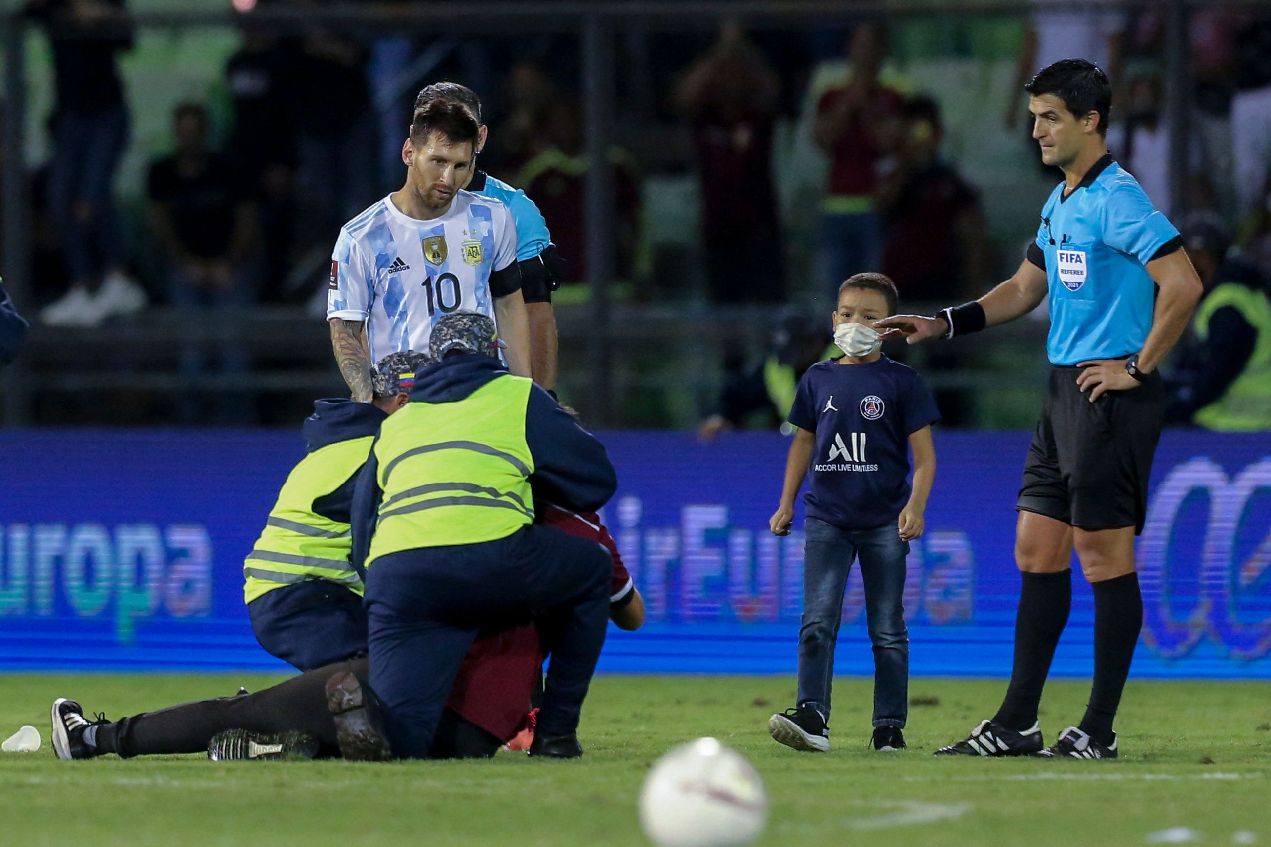 Un niño venezolano burló a la seguridad del estadio y logró llegar a Leo Messi para darle un abrazo. El delantero del PSG le devolvió el gesto. Mientras que otro aficionado no tuvo la misma suerte. En la foto lo detiene la seguridad del Estadio Olímpico de Caracas. Foto Prensa Libre: AFP.