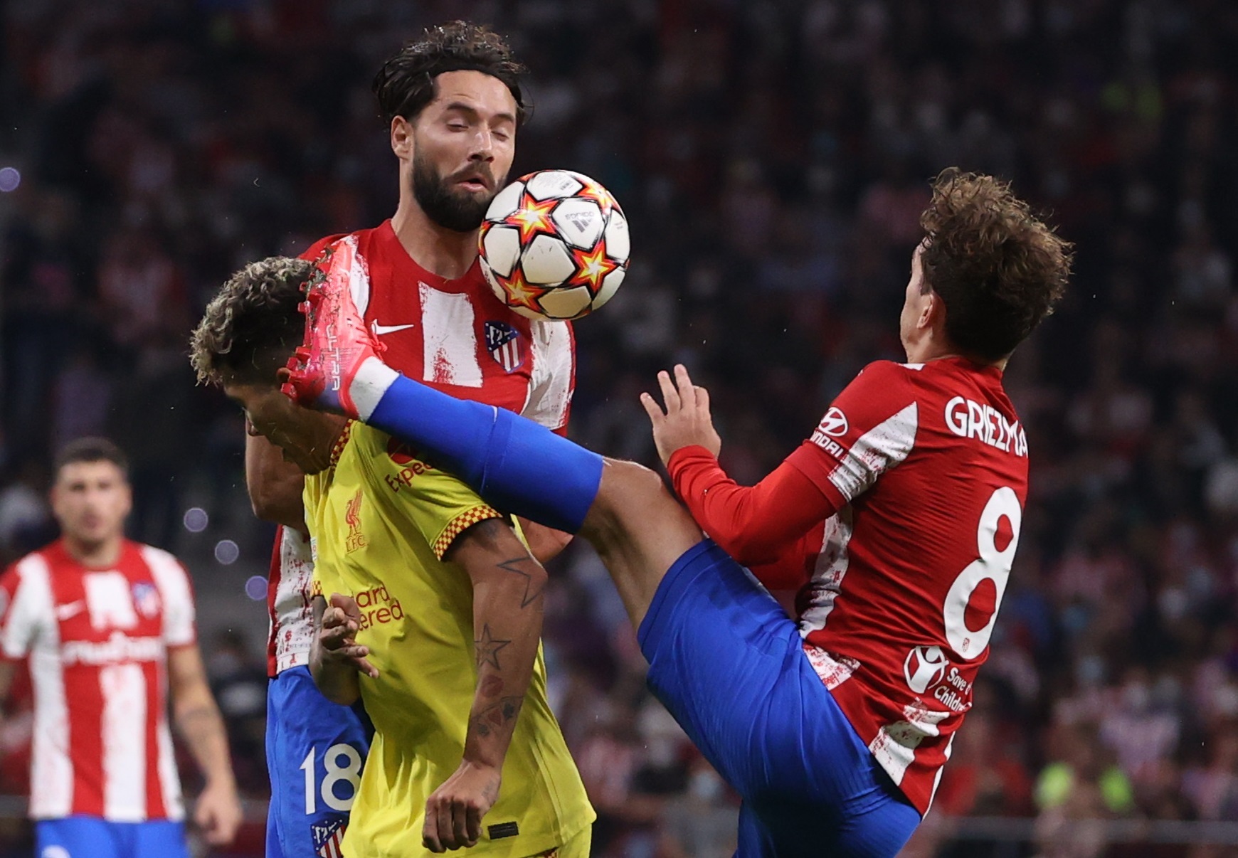 El delantero francés del Atlético de Madrid, Antoine Griezmann (d), comete falta sobre el jugador brasileño del Liverpool, Roberto Firmino, en la jugada que ha significado la expulsión del jugador rojiblanco. Foto Prensa Libre EFE / Juanjo Martín.