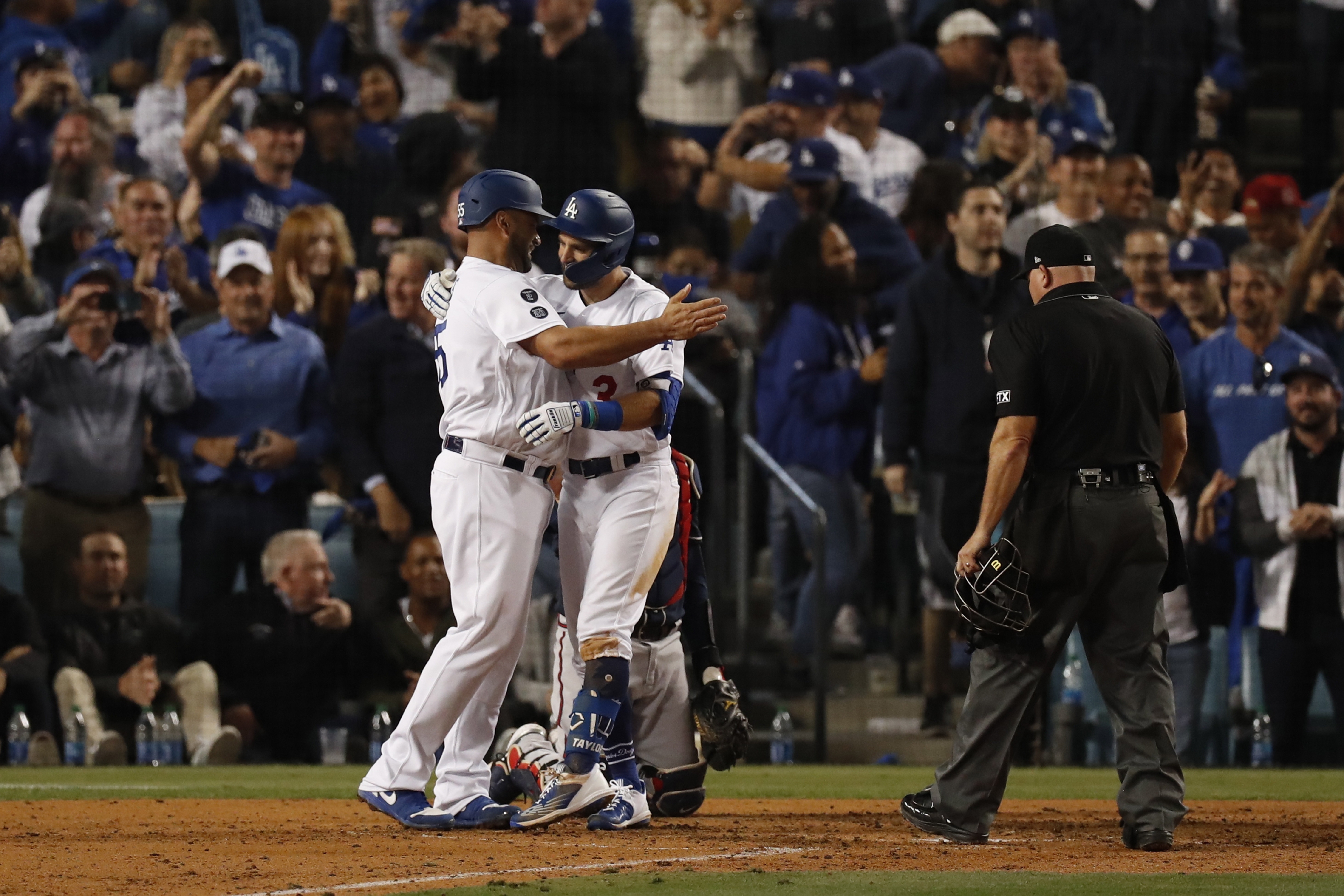 Los jugadores de los Dodgers de Los Ángeles Chris Taylor (C) y Albert Pujols (I) se abrazan en el plato de home y celebran un jonrón de dos carreras en el partido ante los Bravos de Atlanta. Foto Prensa Libre: EFE.