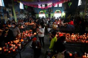 People visit the Temple of San Simon (Saint Simon) in the municipality of San Andres Itzapa, Chimaltenango, Guatemala, on October 28, 2021, during a pagan festival to honour to the saint. - Thousands of devotees bring cigarettes and spirits offerings to the saint --not recognized by the Catholic Church-- who is believed to be the protector of the homeless, prostitutes, alcoholics and drug-traffickers. (Photo by Johan ORDONEZ / AFP)