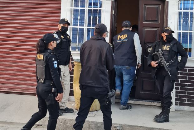 Fiscales del MP y agentes de la PNC en uno de los operativos contra una banda de falsificación de documentos de viaje e identidad que eran enviados a migrantes en Estados Unidos. (Foto Prensa Libre: MP)