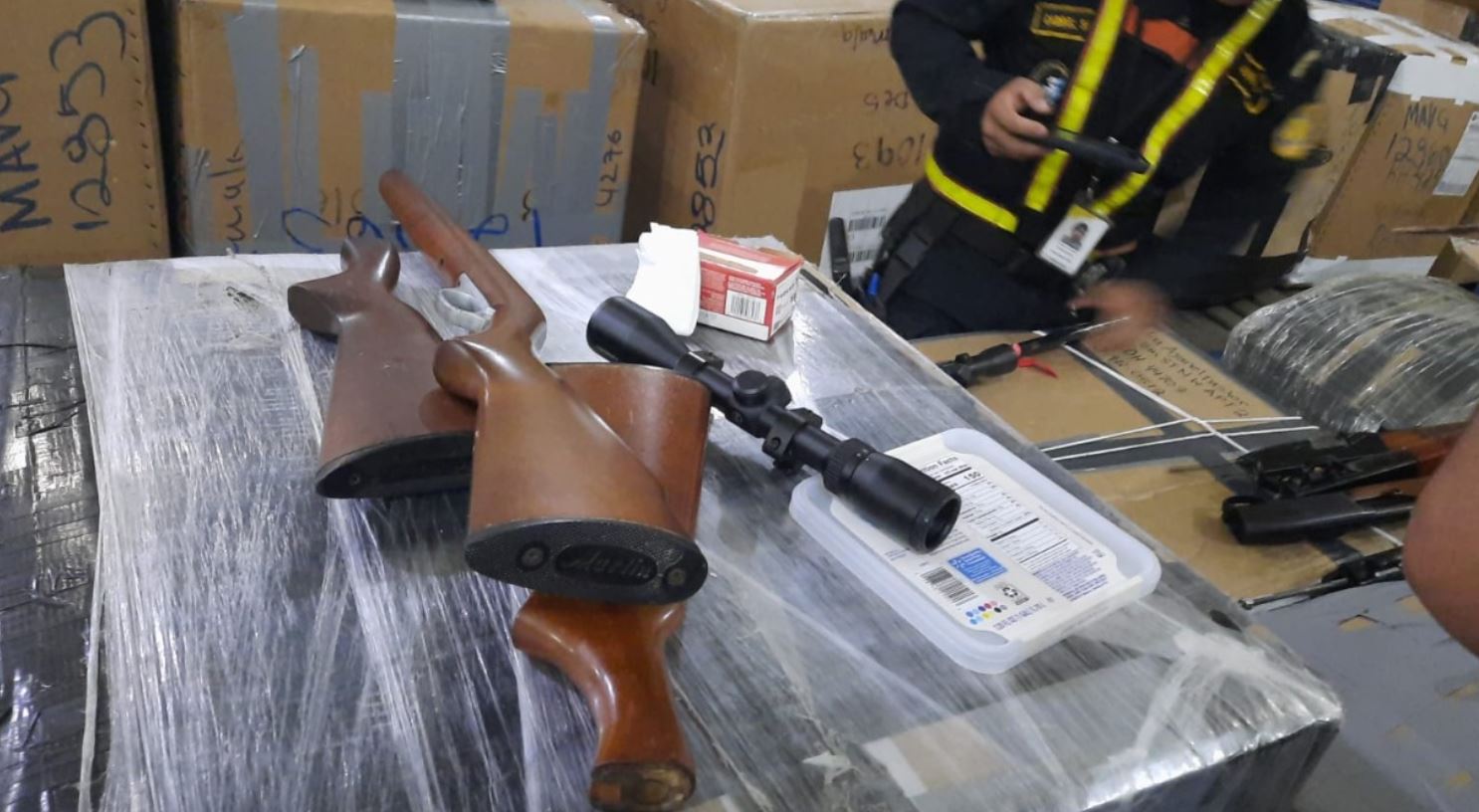 PNC incautó armas y municiones en cajas con encomiendas que estaban en cajas de encomiendas que llegaron en un contenedor que llegó a Puerto Santo Tomás de Castilla procedente de Estados Unidos. (Foto Prensa Libre: PNC)
