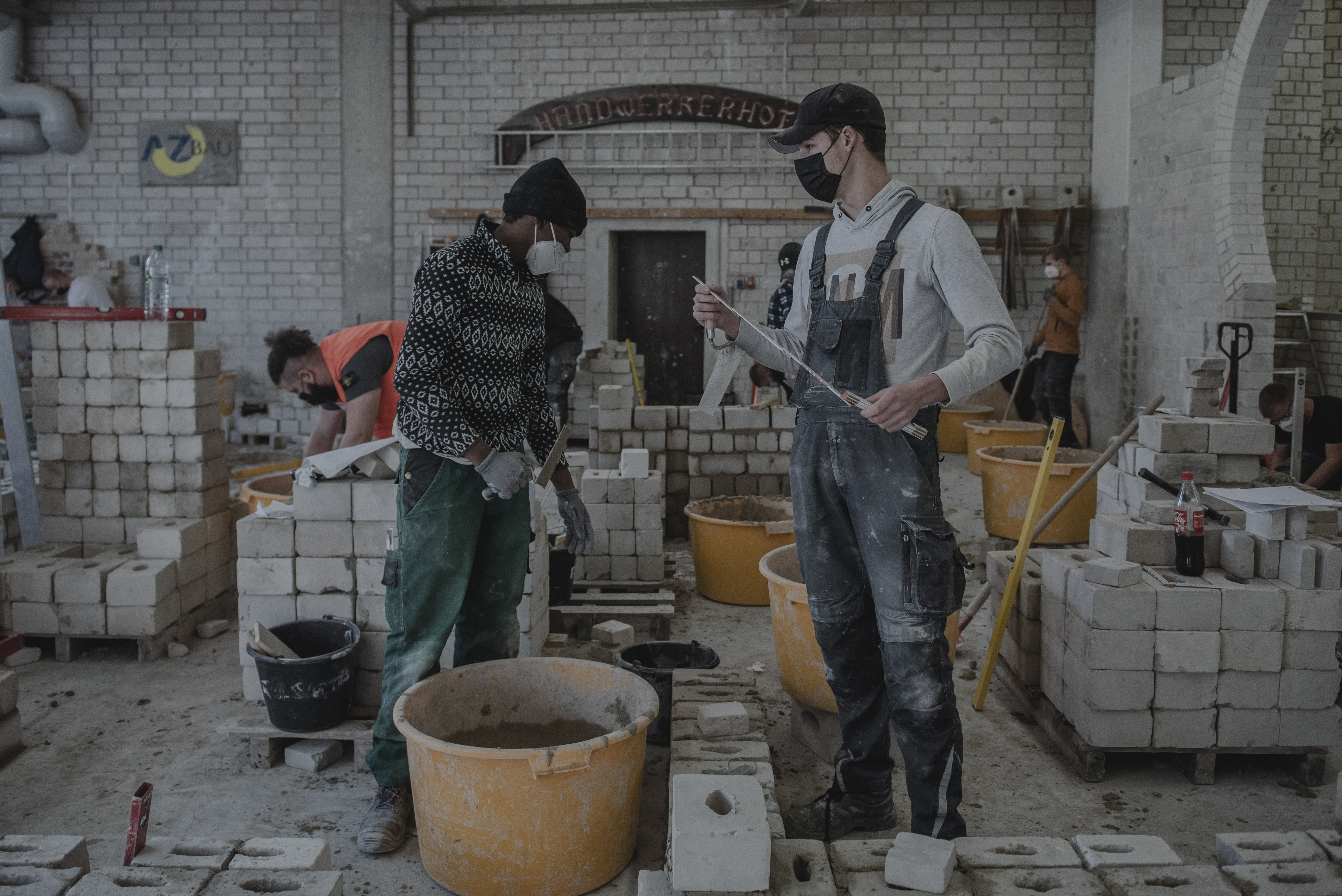 Inmigrantes participan en una clase de albañilería en Bildungskreis Handwerk, un centro de capacitación regional en Dortmund, Alemania. Después de que la pandemia detuvo la migración, Alemania y otros países que enfrentan una fuerza laboral envejecida y escasez de trabajadores ahora están compitiendo para reclutar, capacitar e integrar a los extranjeros. (Foto Prensa Libre: Laetitia Vancon / The New York Times)
