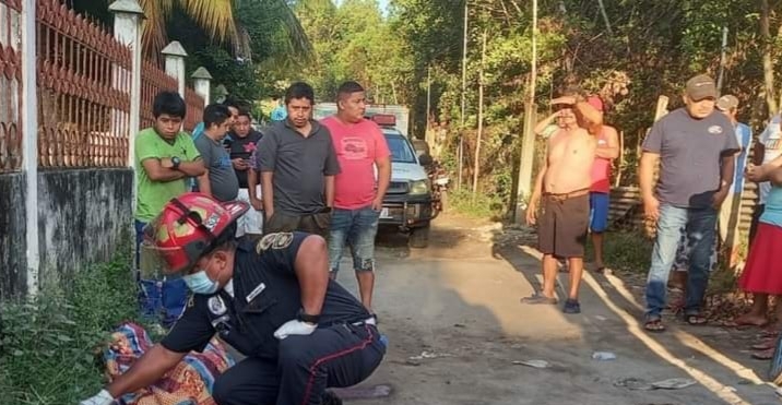 Un bombero municipal cubre el cadáver de un hombre que fue decapitado en La Blanca, San Marcos. (Foto Prensa Libre: CBMD)