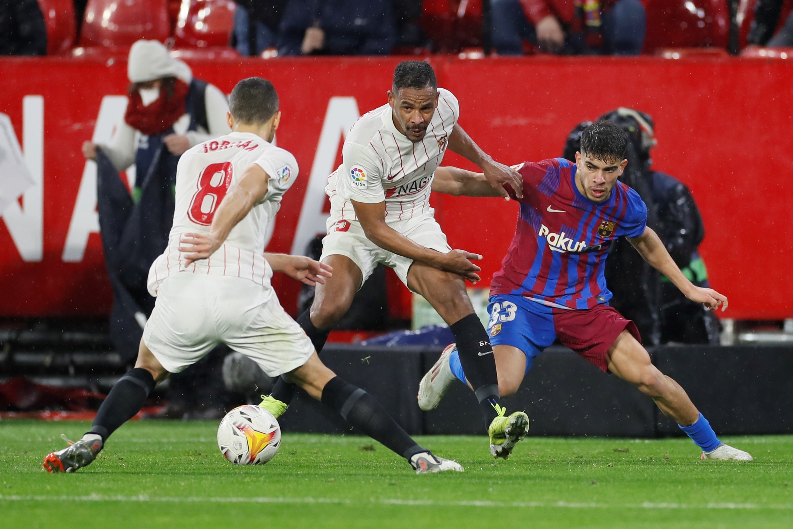 El defensa brasileño del Sevilla FC Fernando Reges (C) pelea un balón con Abdessamad Ezzalzouli, del FC Barcelona. (Foto Prensa Libre: EFE)
