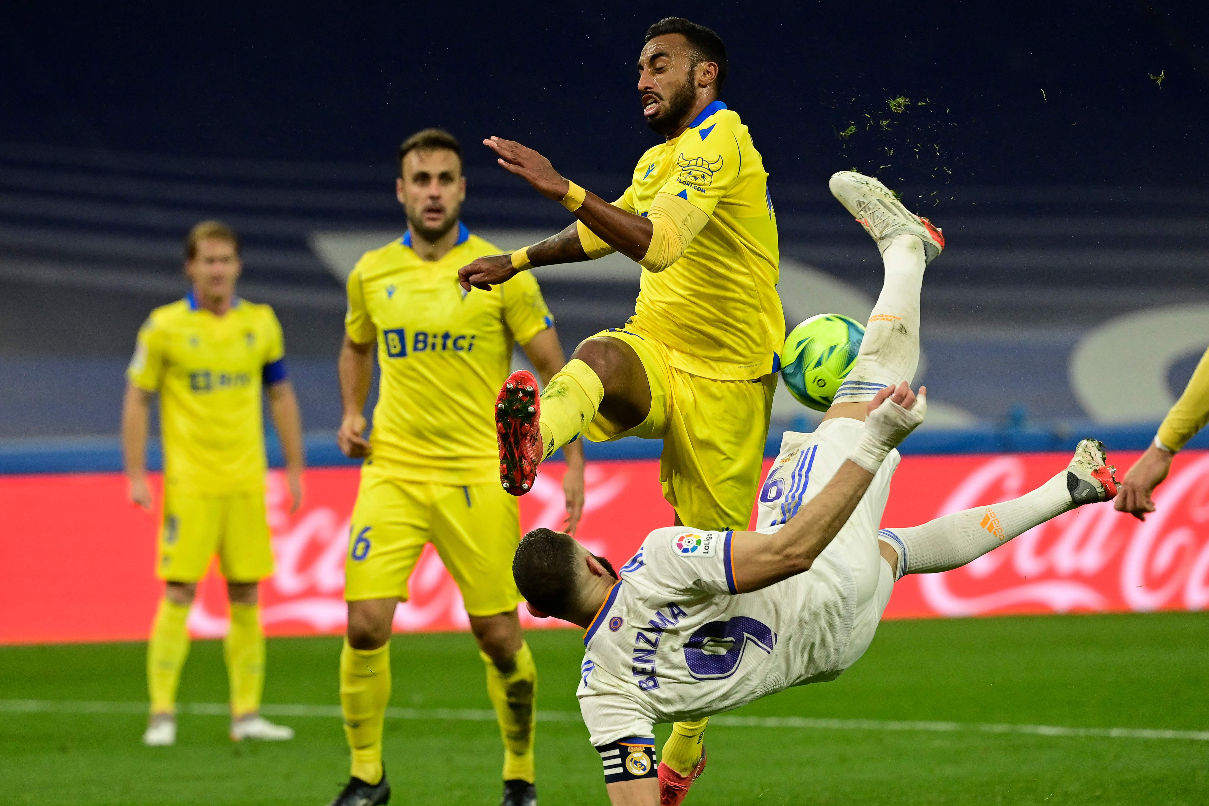 El defensa de Cádiz CF Carlos Akapo (de pie) disputa el balón al delantero del Real Madrid Karim Benzema. (Foto Prensa Libre: AFP)