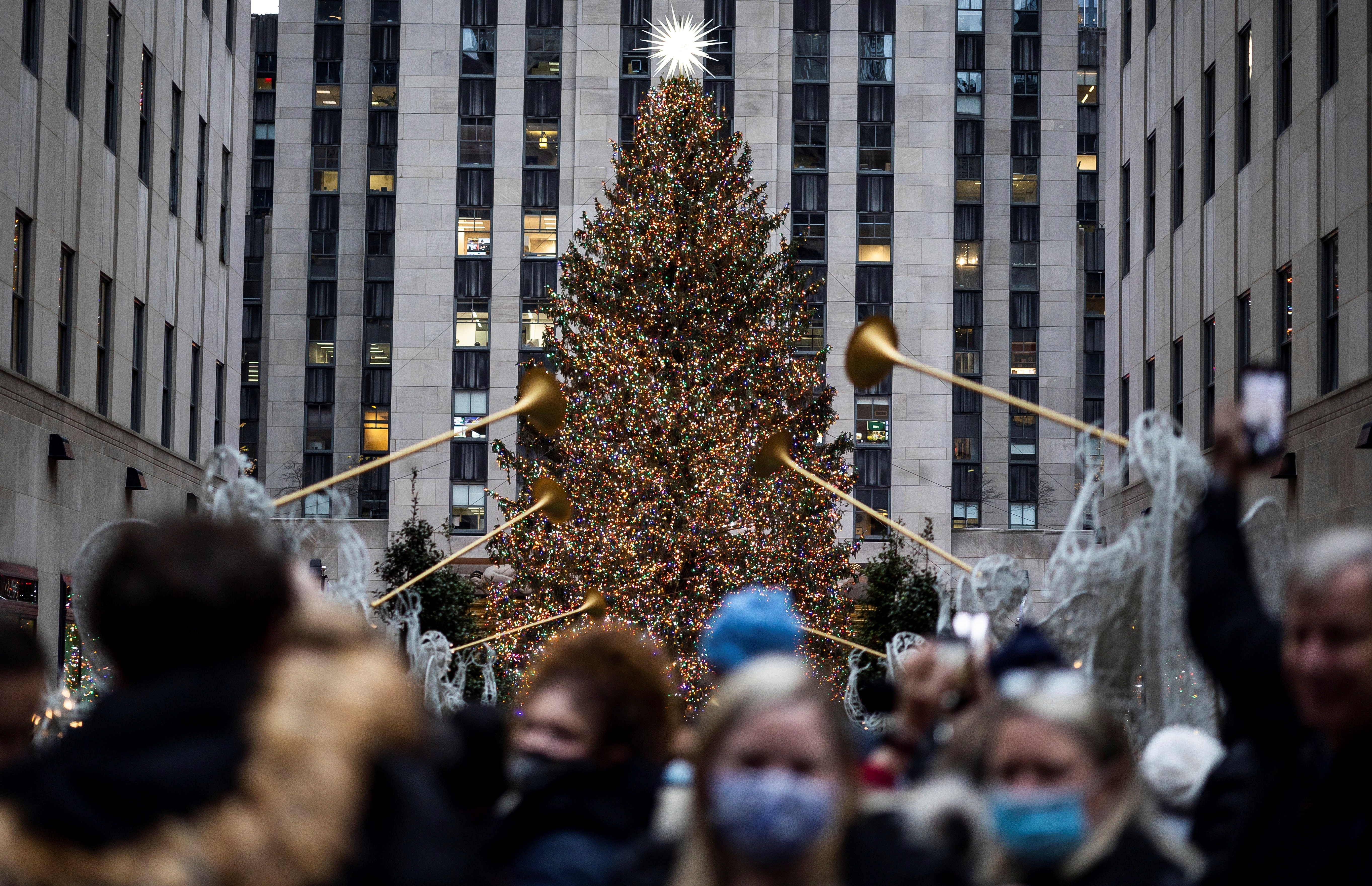 Turistas se reúnen cerca del árbol de navidad en el Rockefeller Center de Nueva York, cuando las autoridades anuncian este jueves que en esa ciudad hay cinco casos positivos de la variante ómicron. (Foto Prensa Libre: EFE)