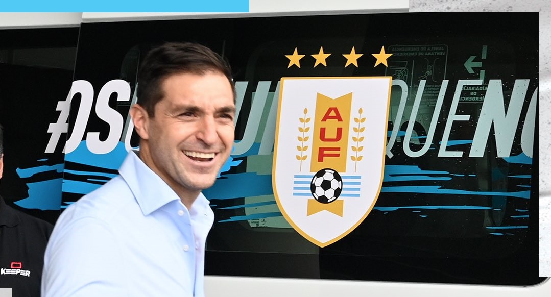 El nuevo seleccionador de Uruguay Diego Alonso posa al lado del autobus oficial de ese seleccionado al momento de su presentación. (Foto Prensa Libre: Twitter)