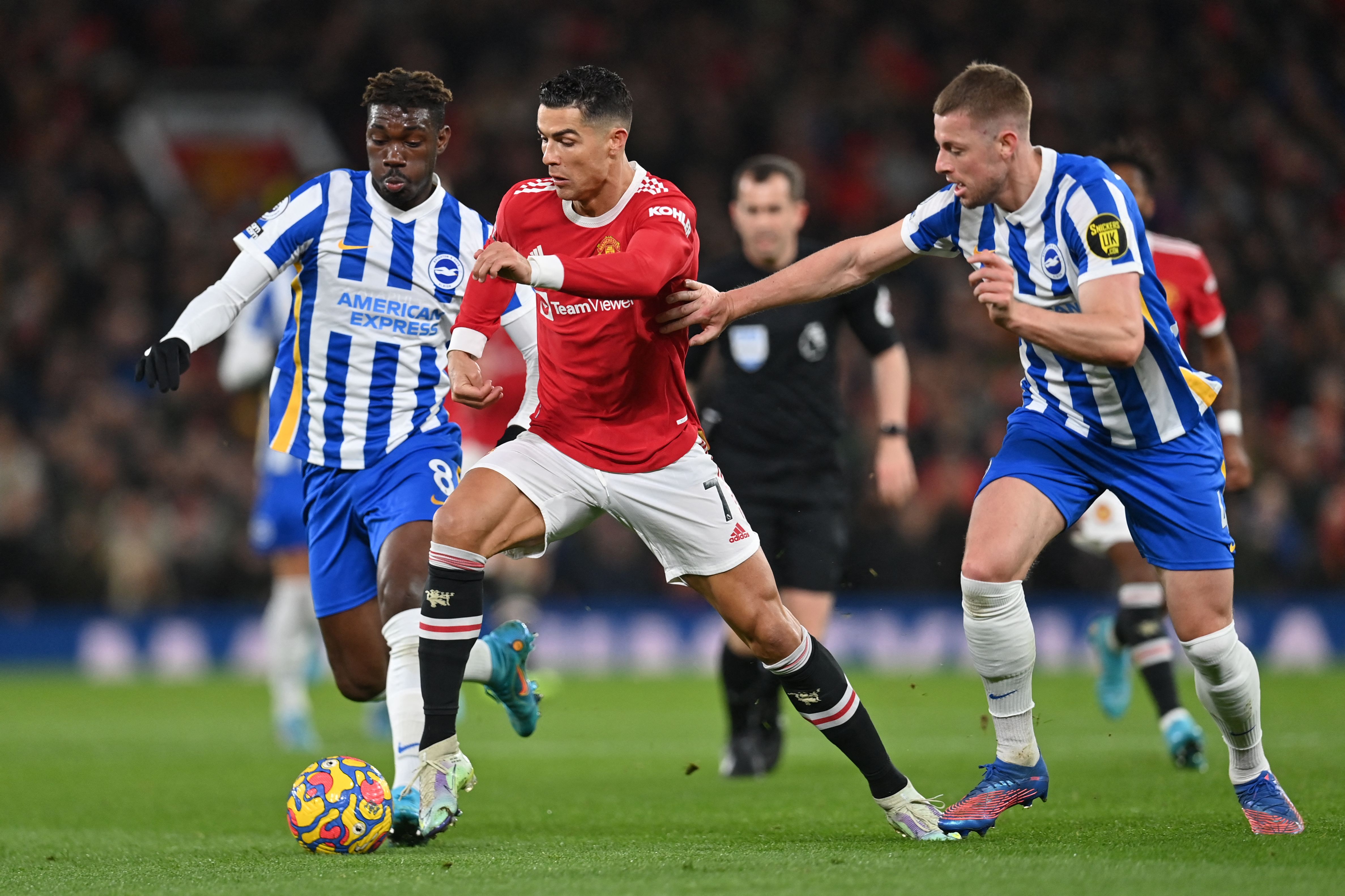 El delantero portugués del Manchester United, Cristiano Ronaldo (C) pelea por un balón con los jugadores del Brighton Yves Bissouma (I) y Adam Webster (D) durante un partido de la Premier League en  Old Trafford. Foto Prensa Libre: AFP.